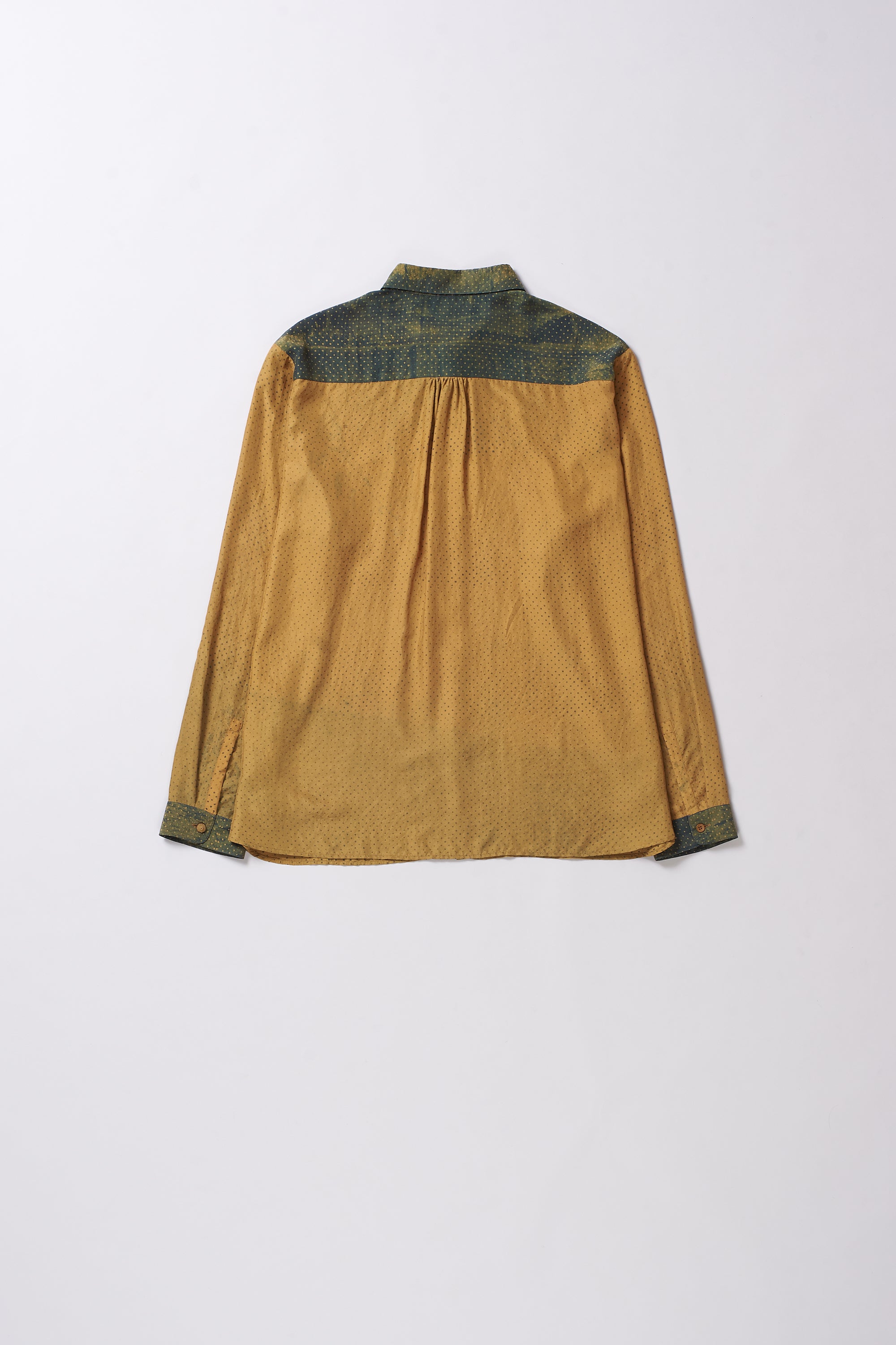 Mustard yellow shirt with green patterned collar on a white background