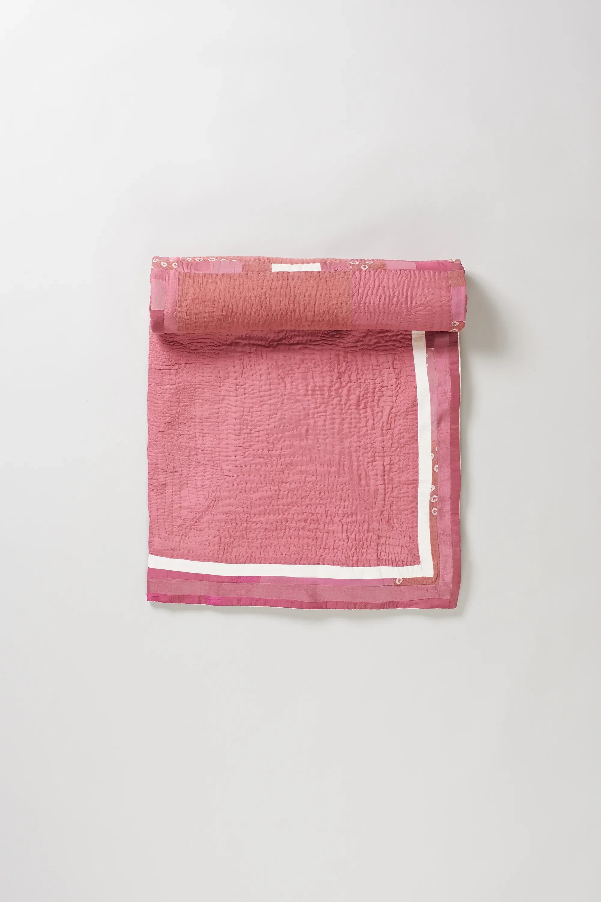 Light pink quilt roll on light grey background