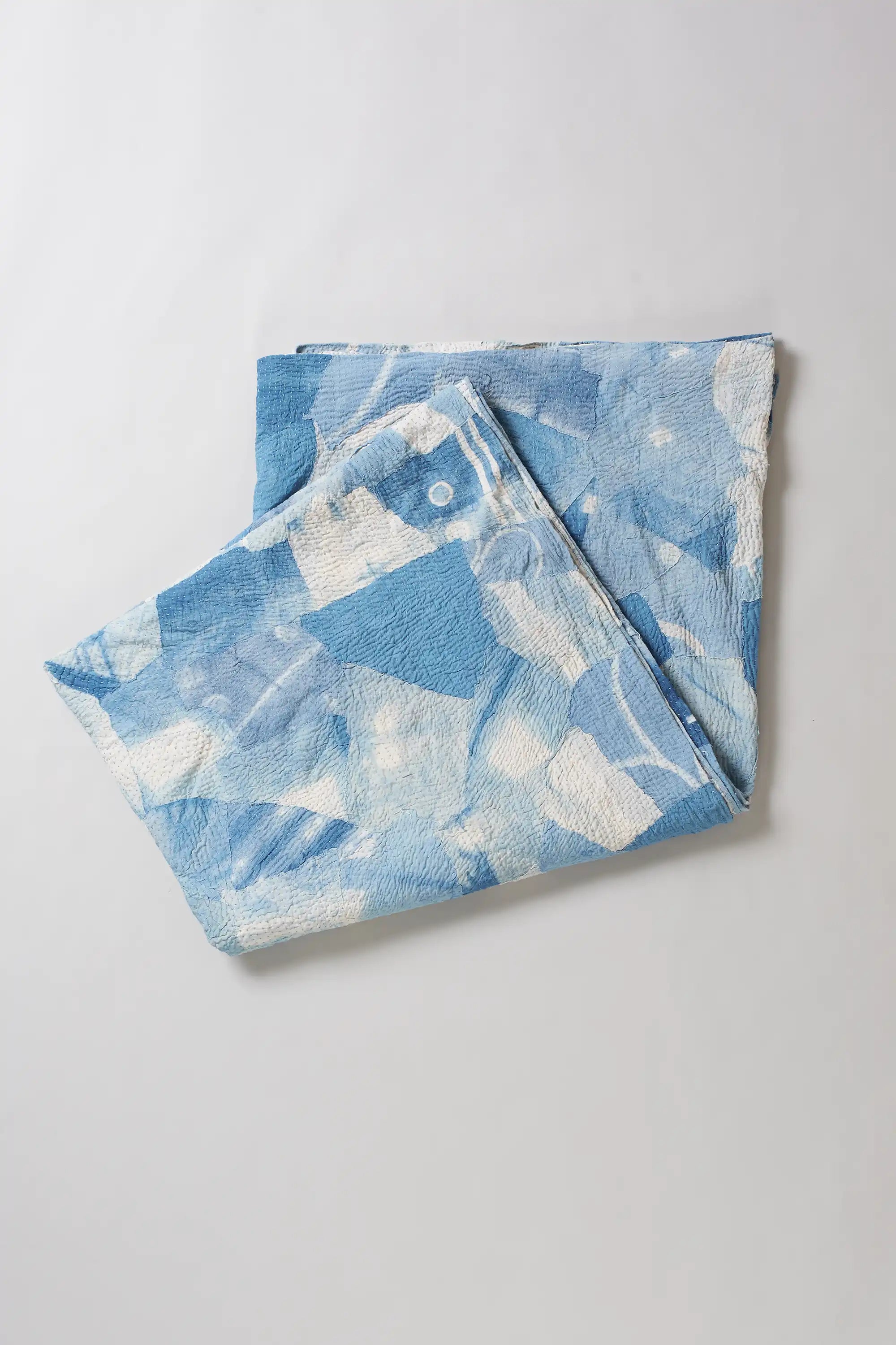 Folded sky indigo quilt on light grey background