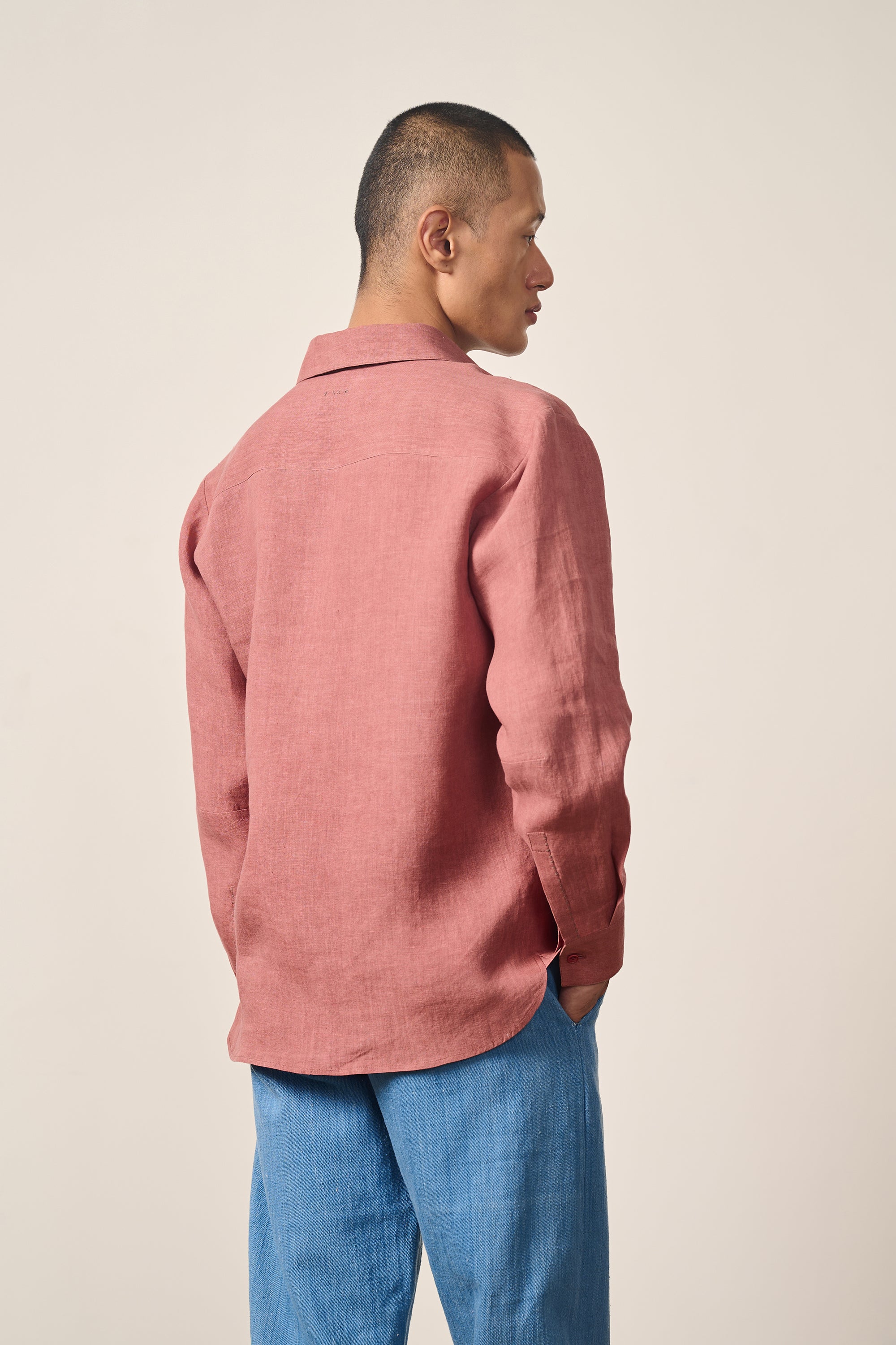 A back shot of a man wearing rouge pink shirt