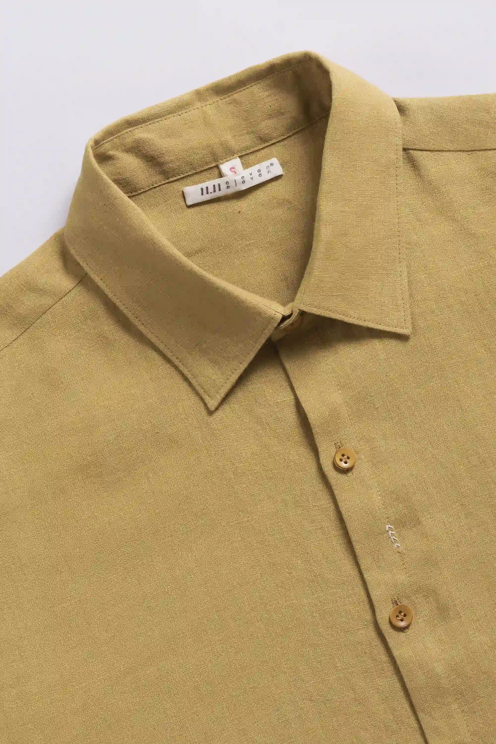 Close-up of a shirt with collar and buttons on a light grey background