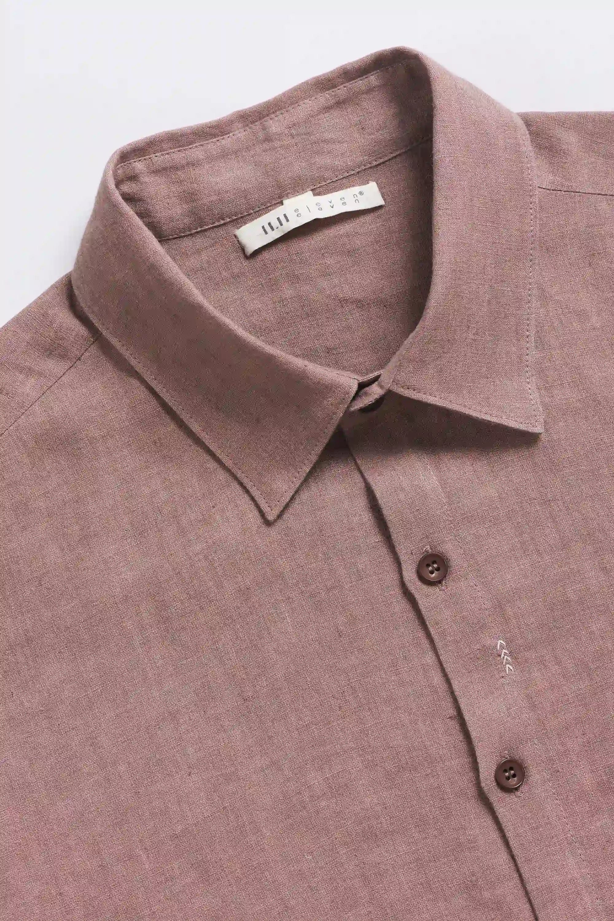 Close-up of a old rose shirt with collar and buttons, with a visible brand label