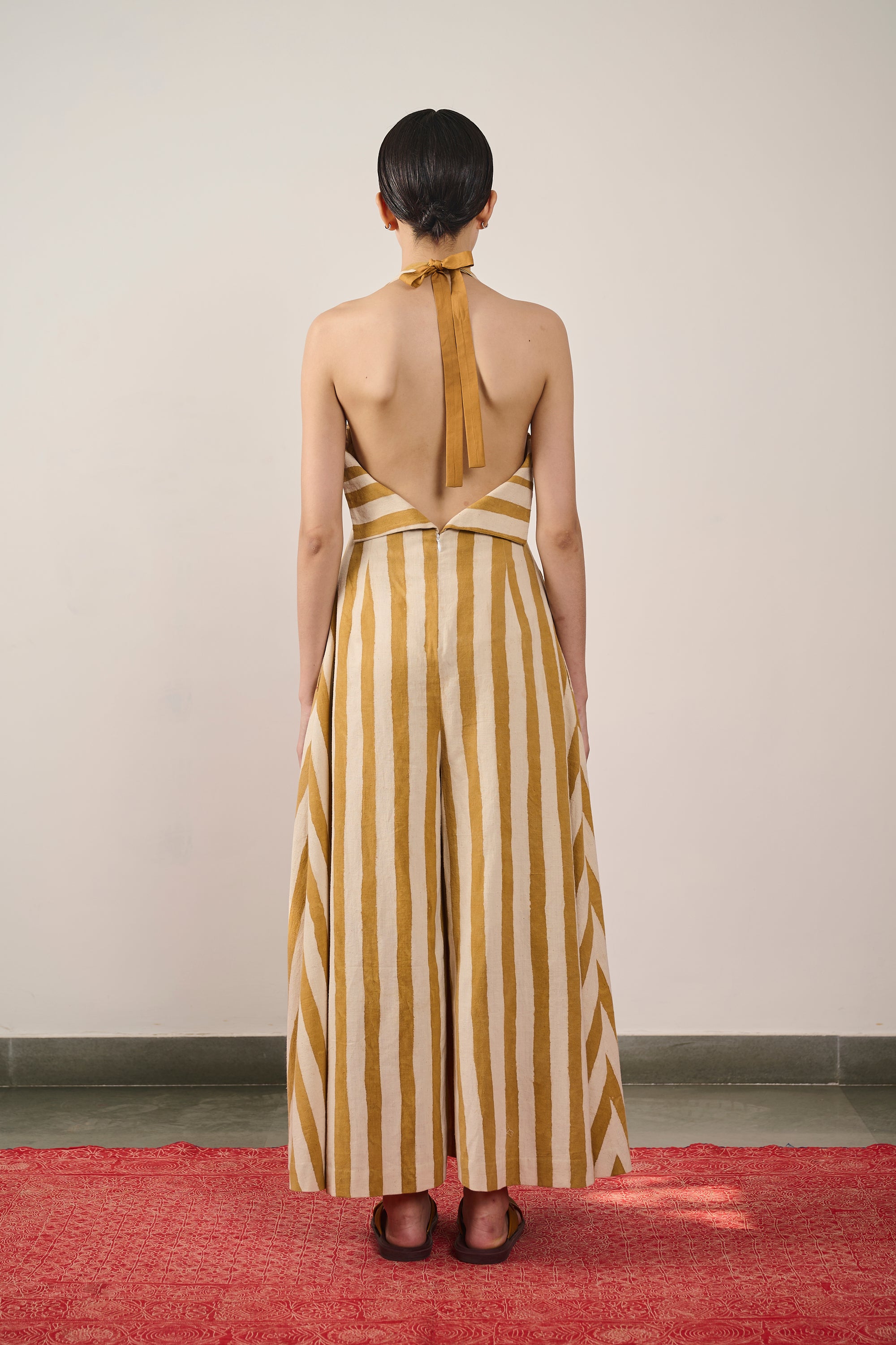 A back shot of a woman wearing mustard yellow dress