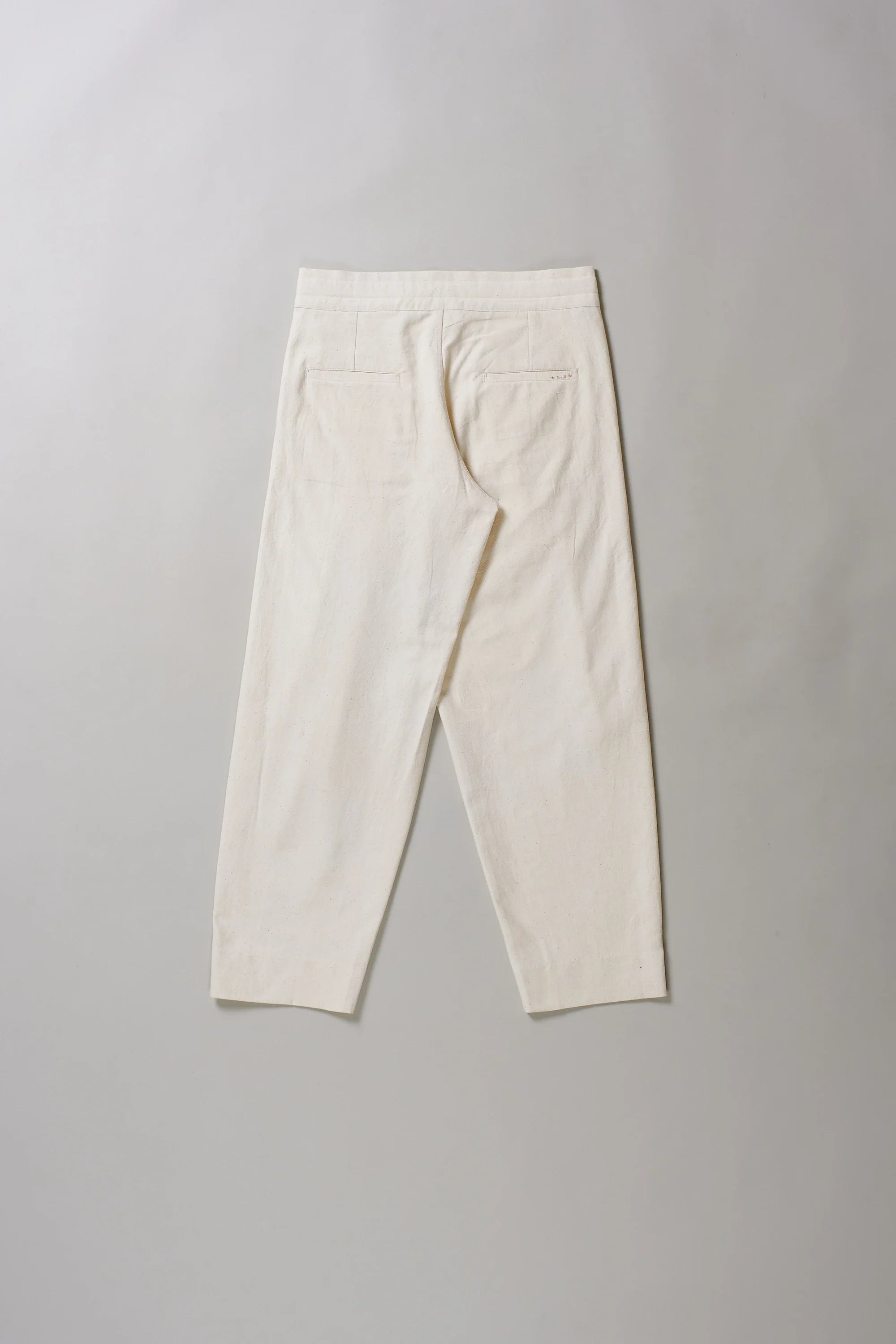 Back image of ecru pants on a grey background