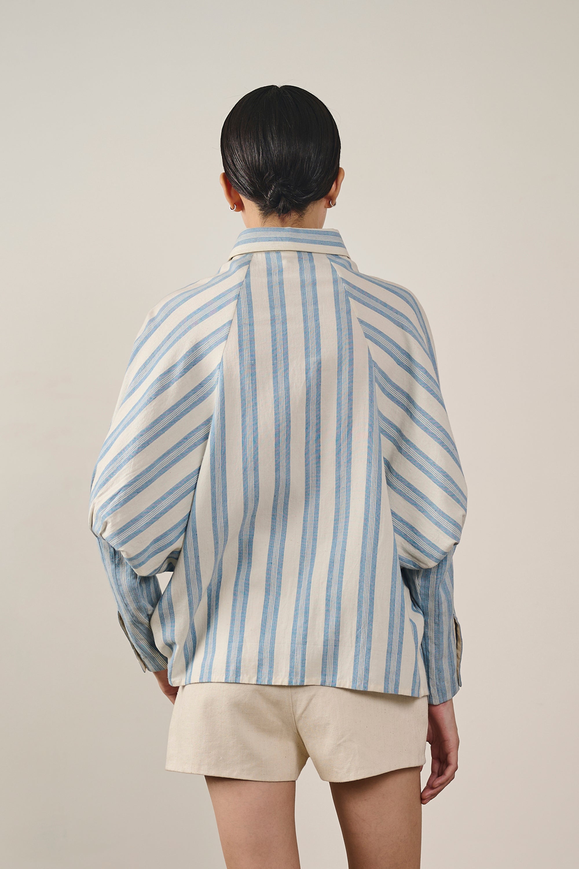 A back shot of a woman wearing light indigo shirt