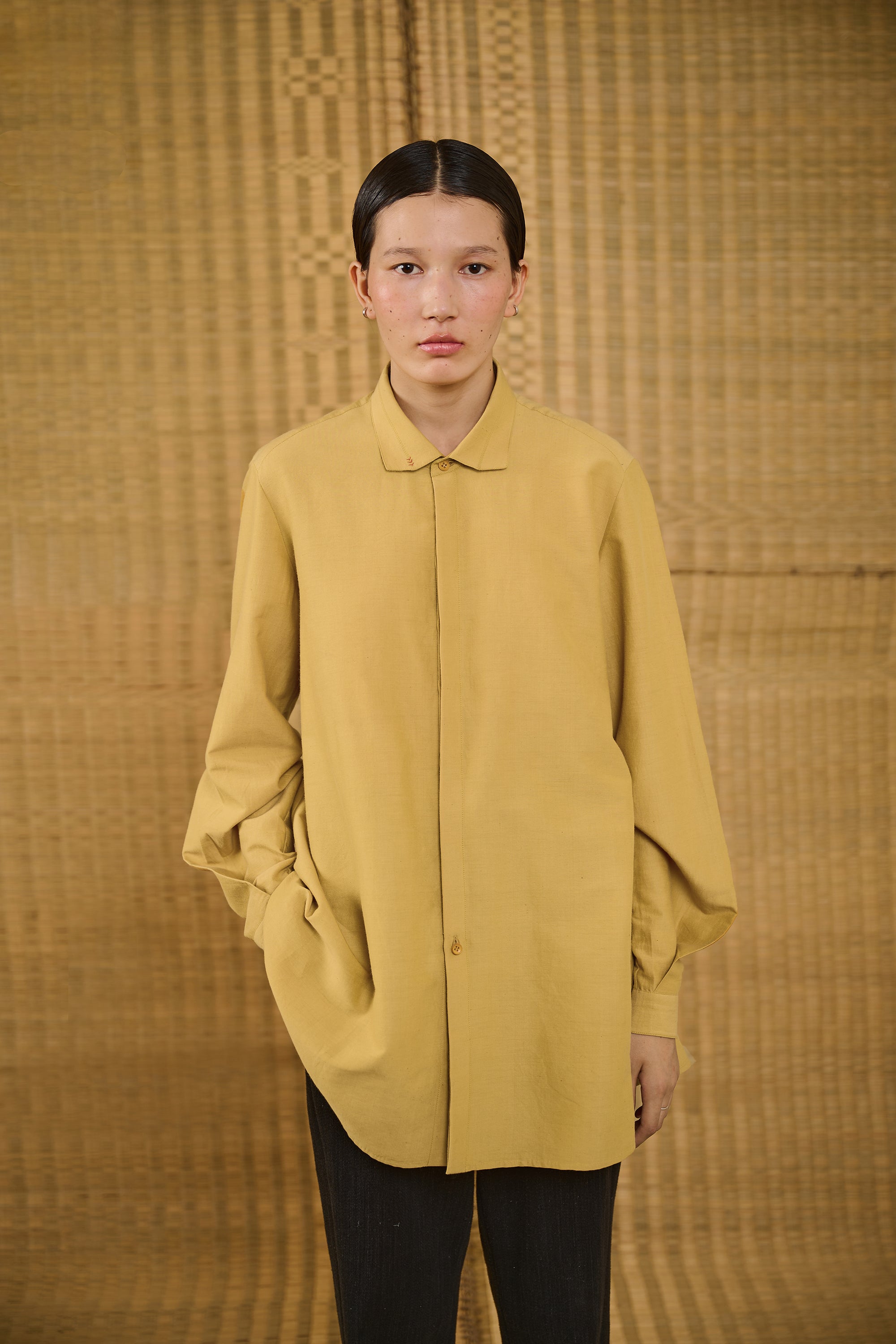 A woman wearing mustard yellow shirt