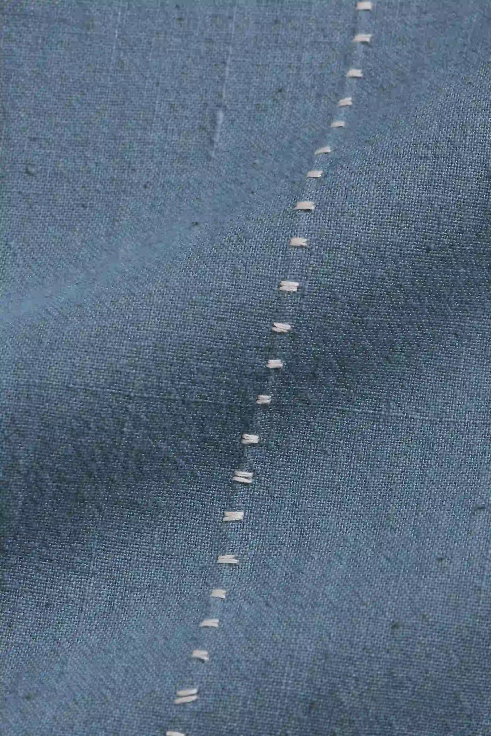 Close-up of a blue cotton fabric with hand detailing
