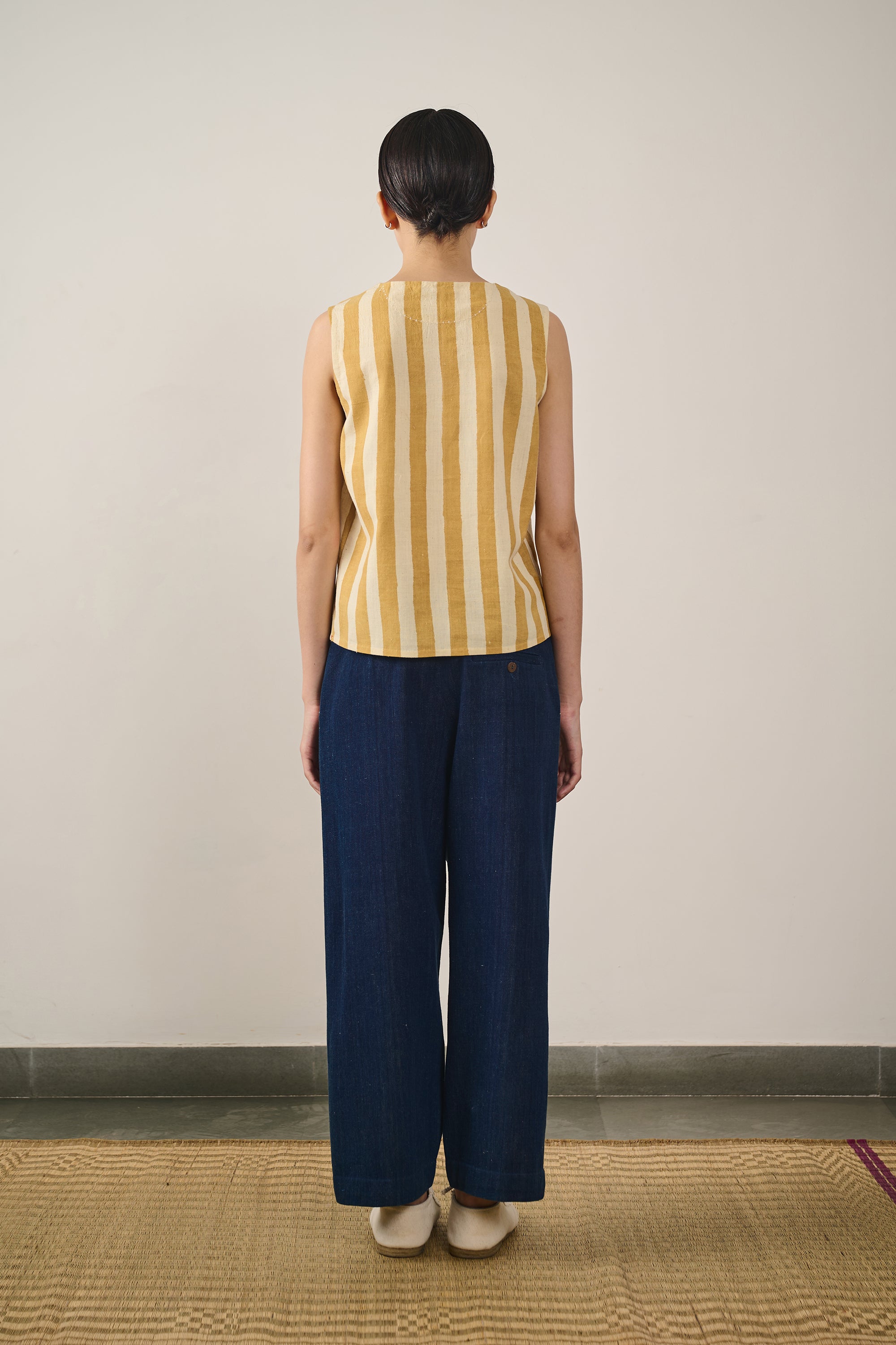 A back shot of a woman wearing mustard yellow top