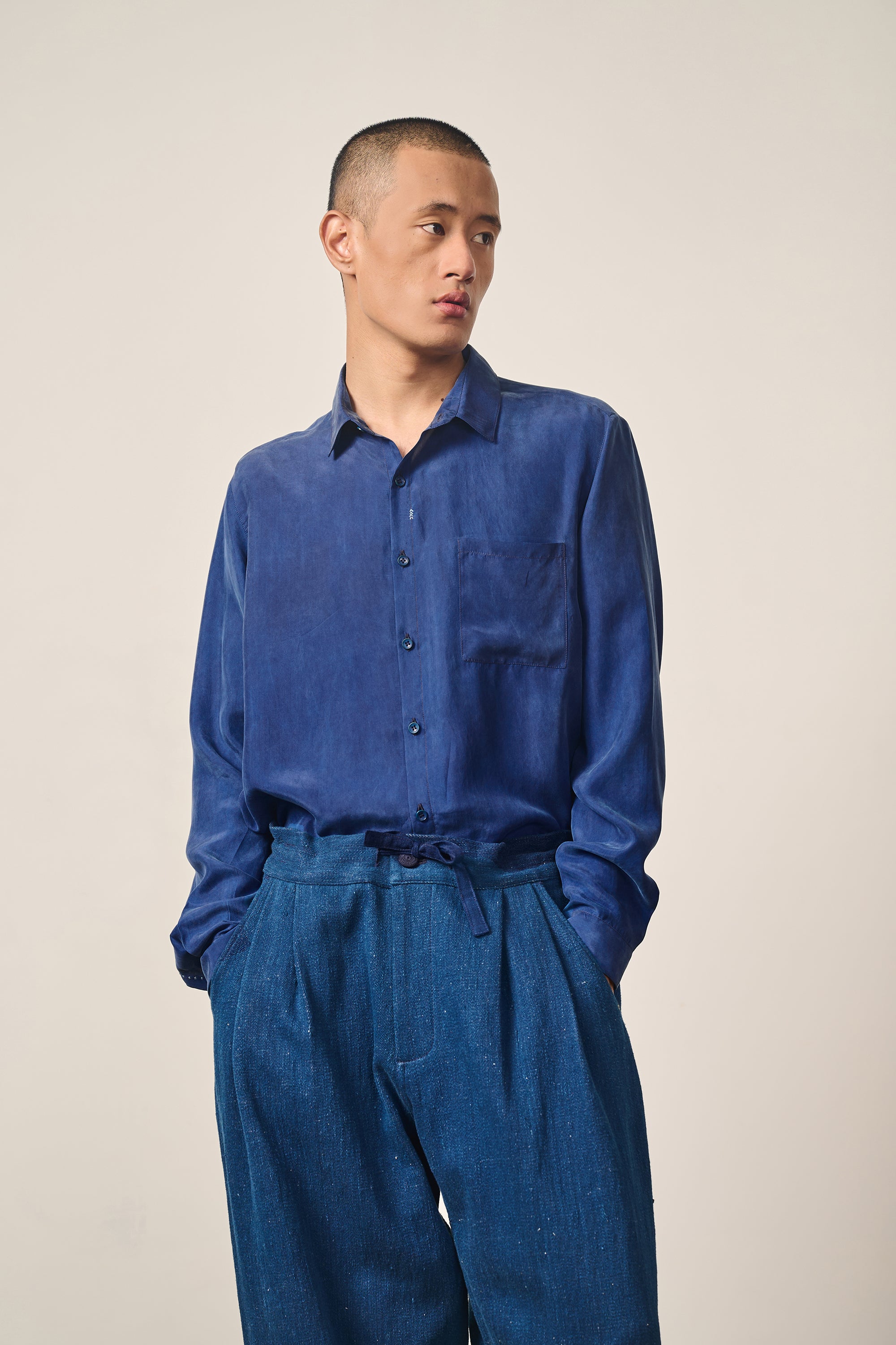 A man wearing medium indigo silk shirt