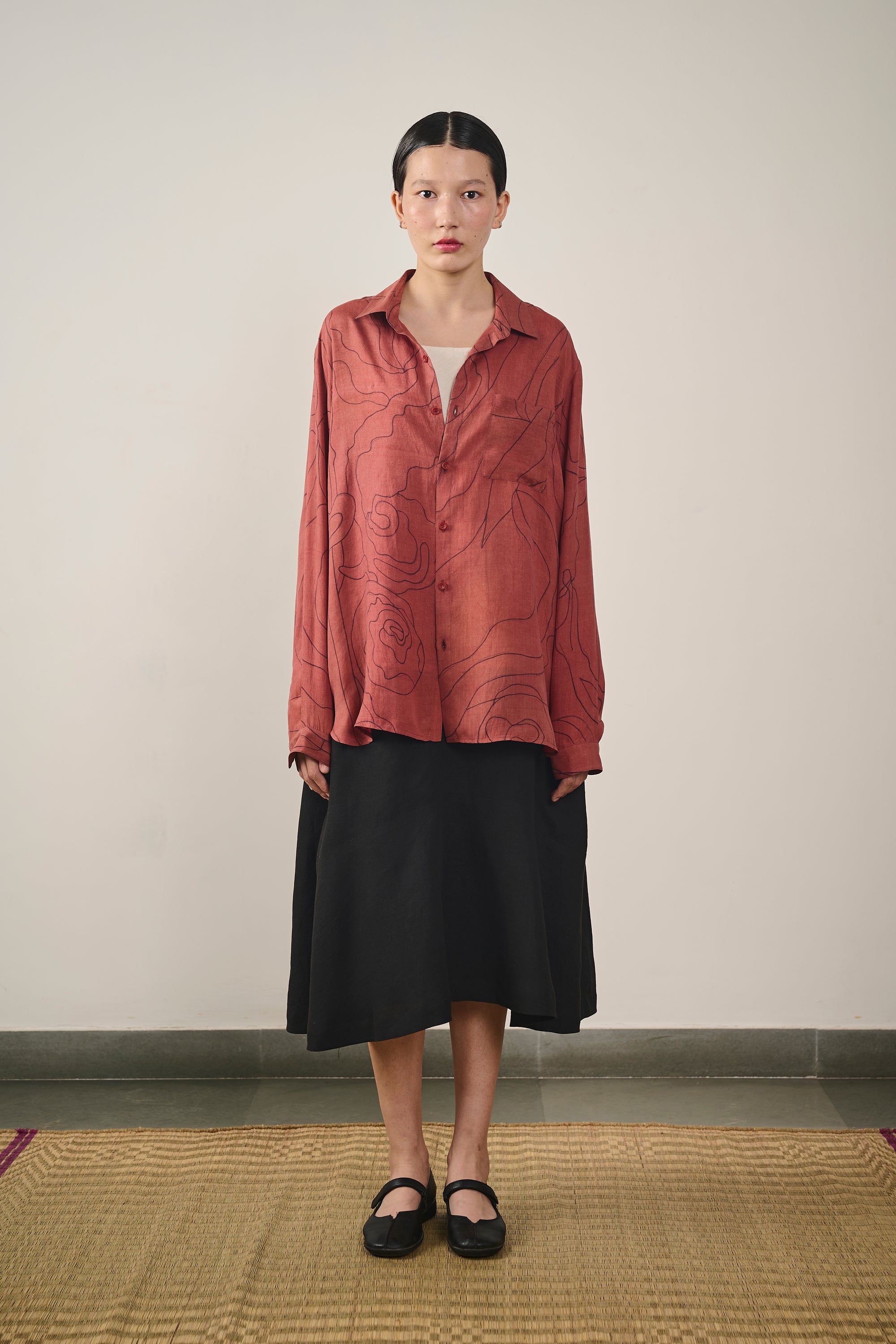 A woman wearing hand painted silk shirt