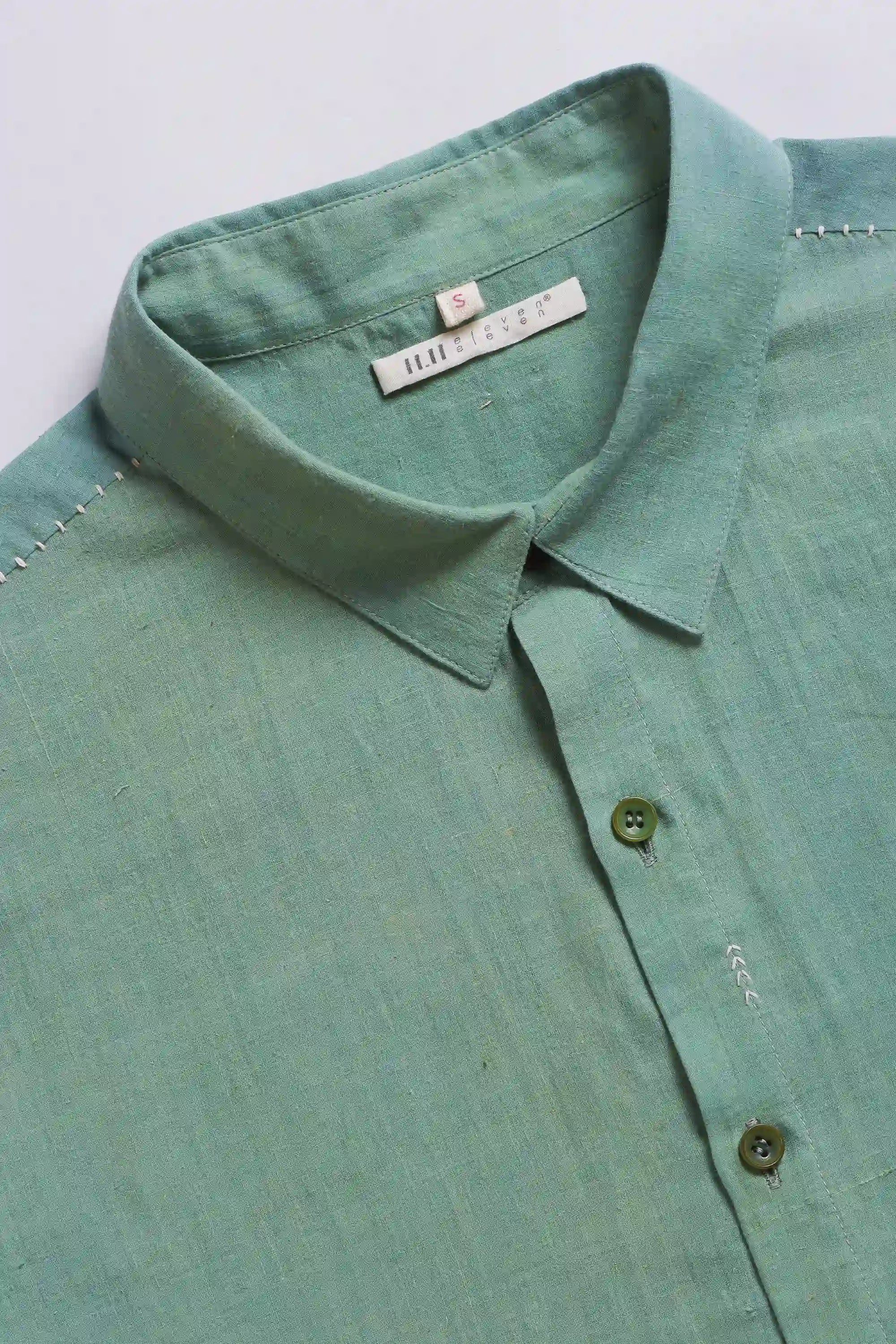 Turf green shirt with collar and buttons details on a light grey background