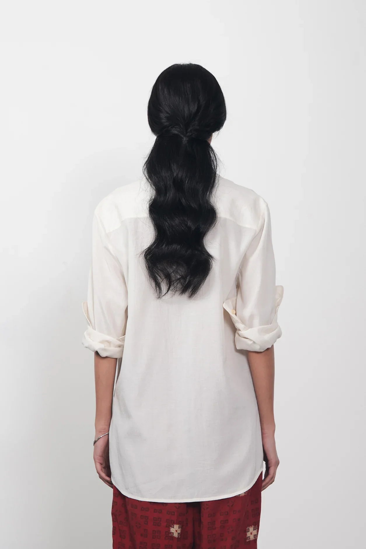 A back shot of a women wearing ecru shirt