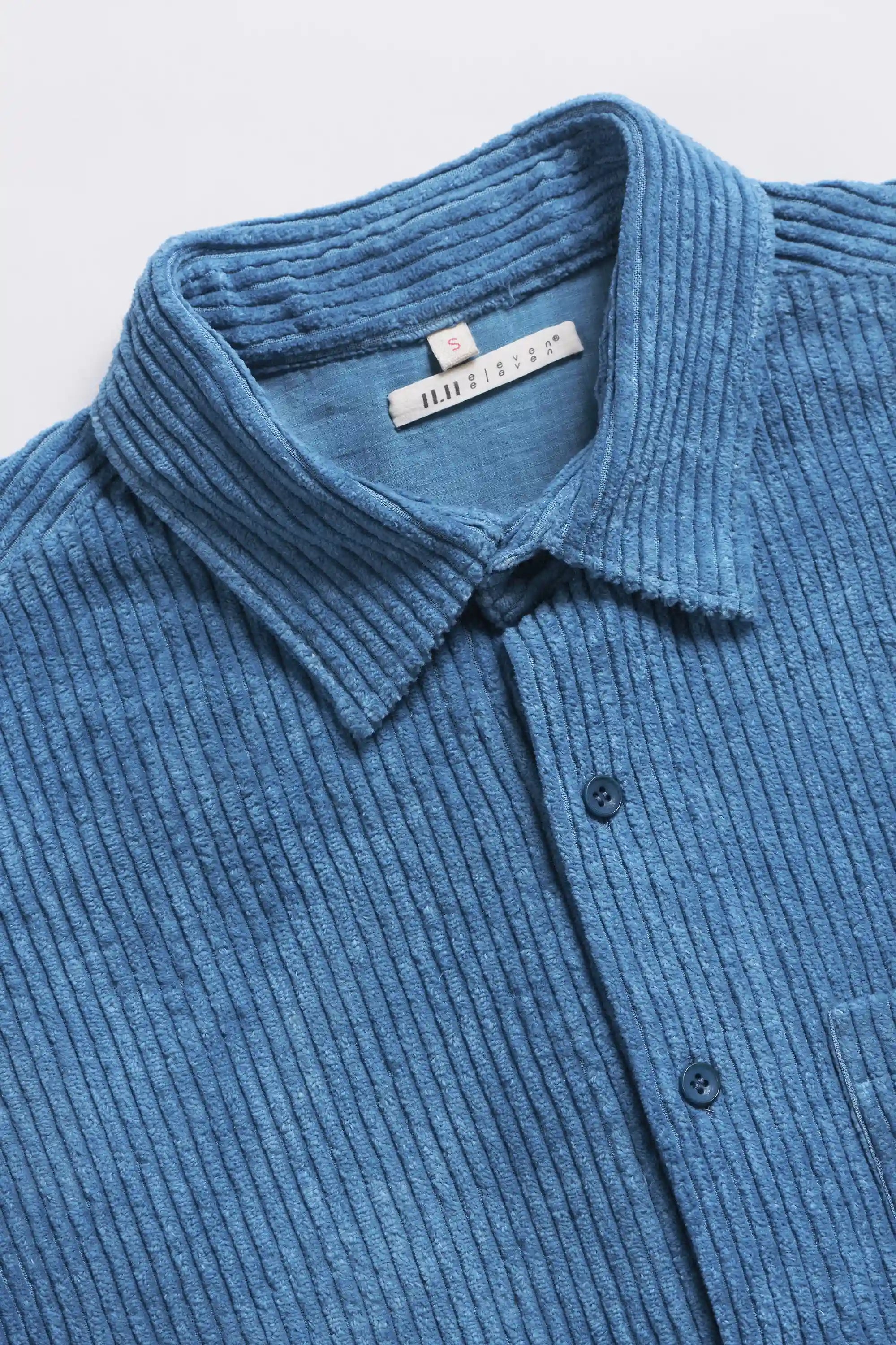 Blue shirt with collar and buttons on a light grey background
