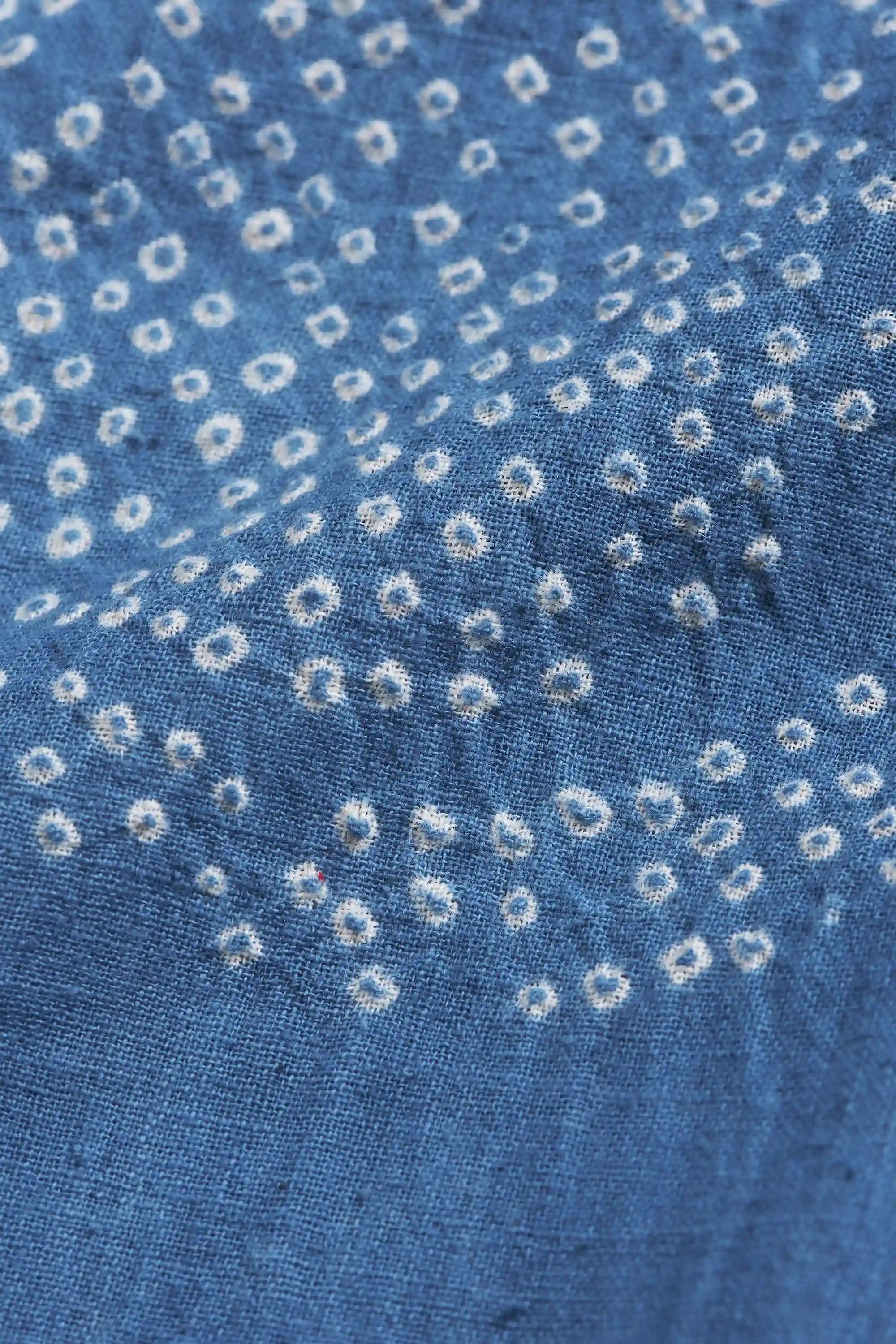 Close-up of blue fabric with bandhani work