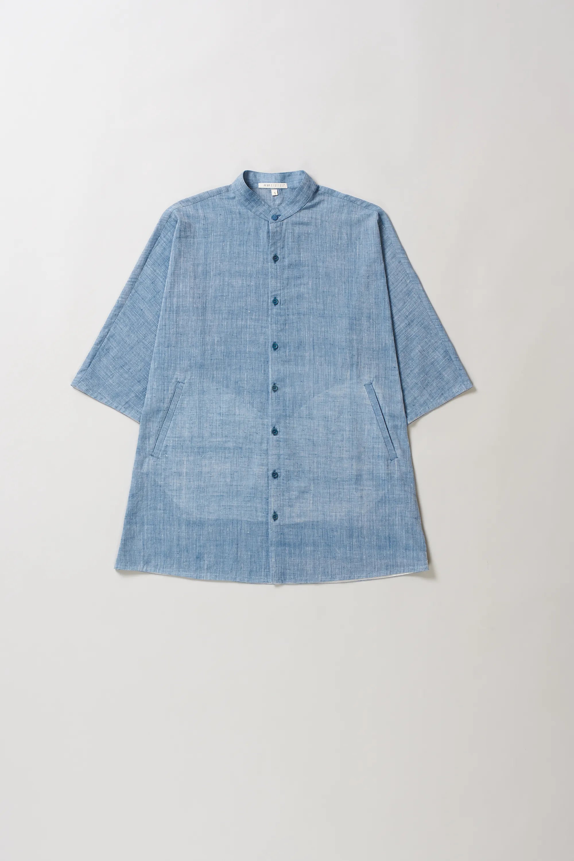 Blue cotton shirt on a light grey background