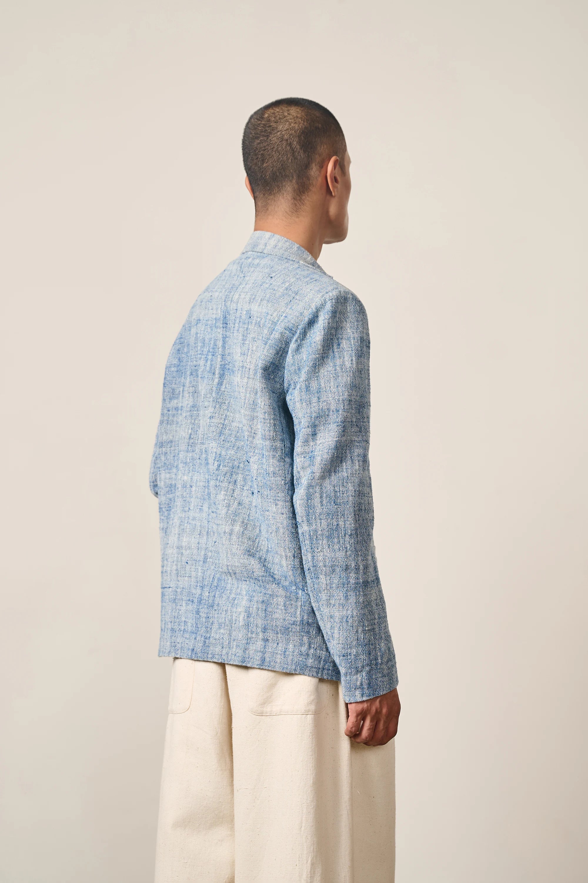 A side shot of a man wearing medium indigo jacket