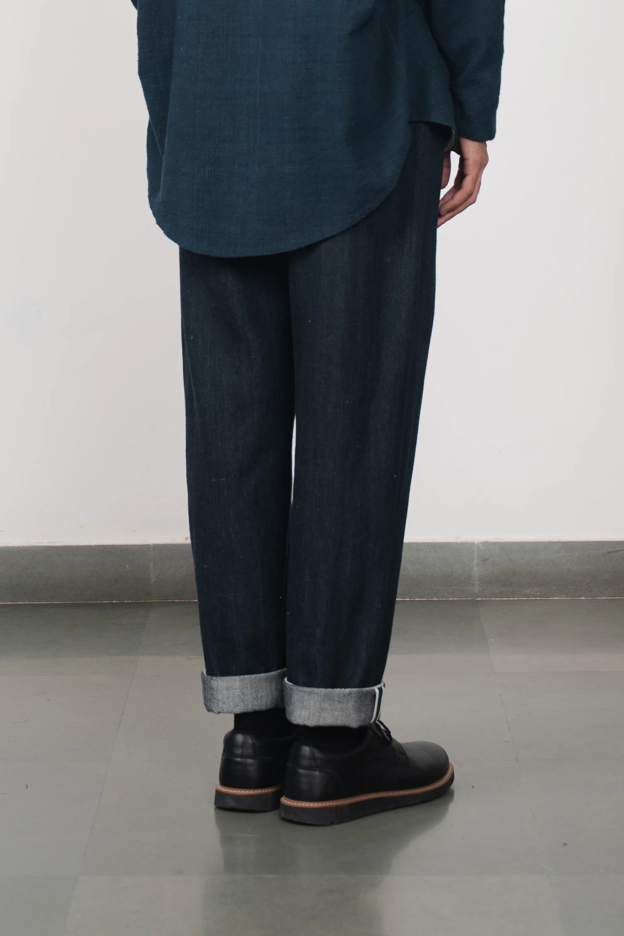 A back shot of a man wearing midnight indigo pant