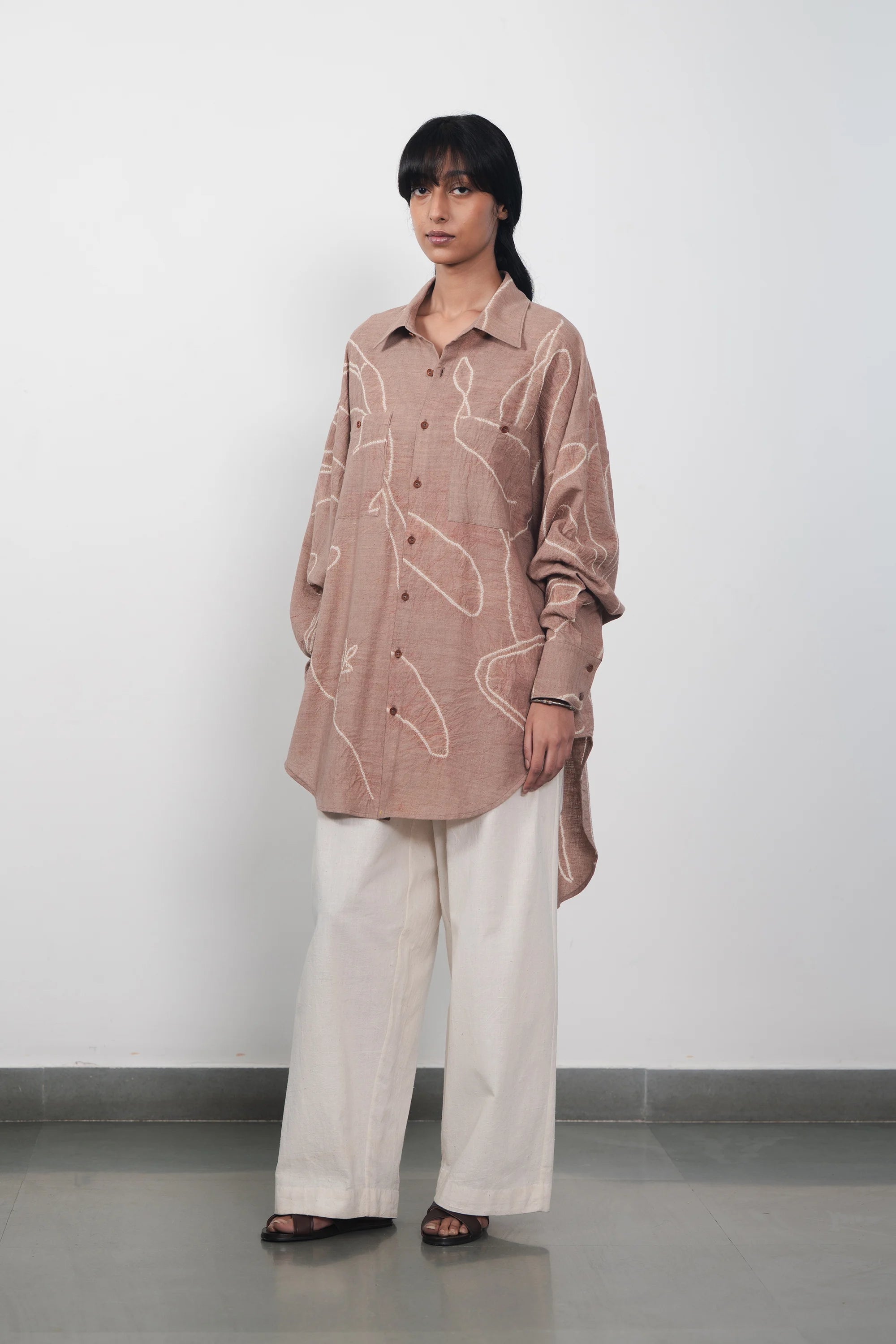 A woman wearing ecru pleated trouser