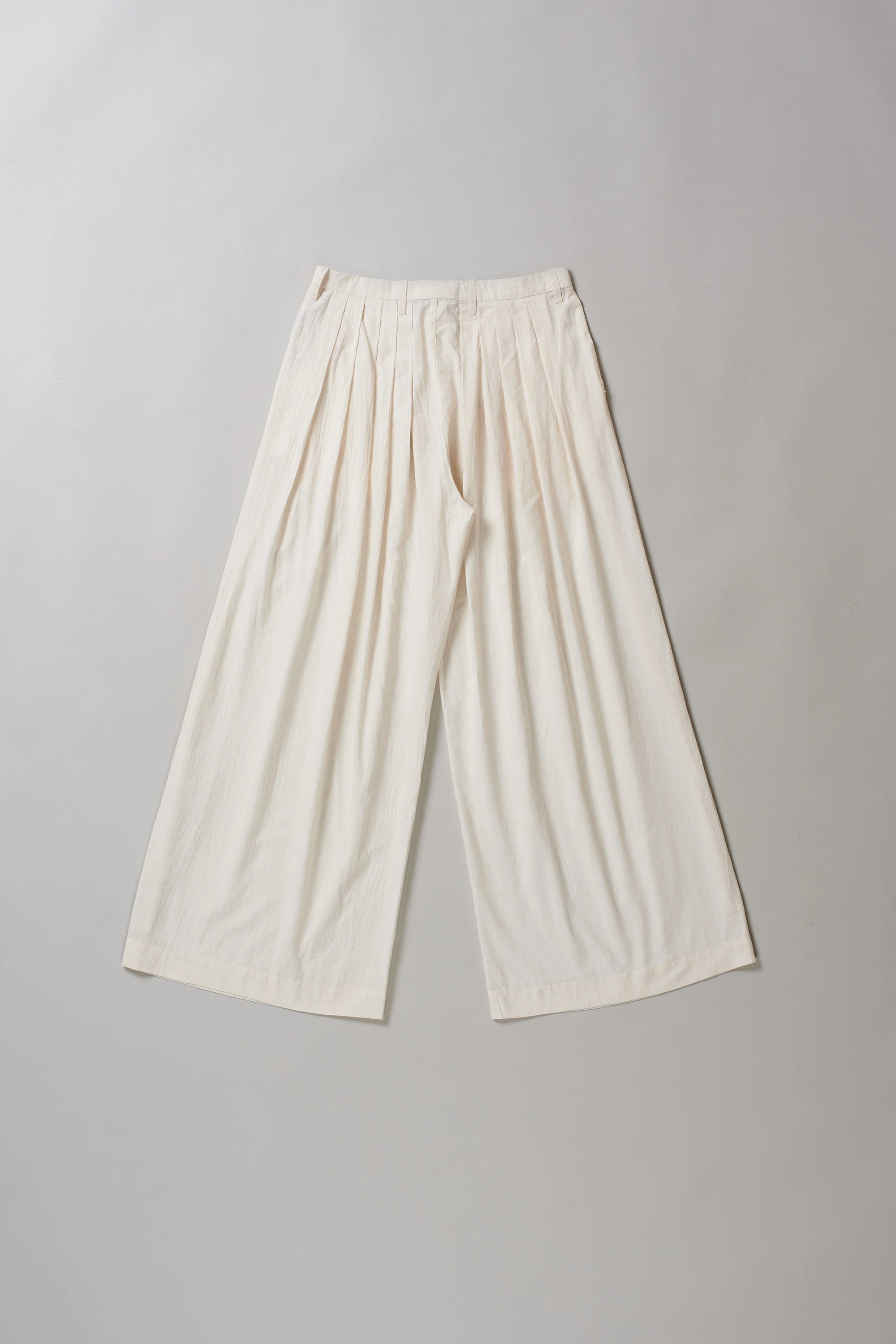 Back image of ecru cotton pants on a grey background