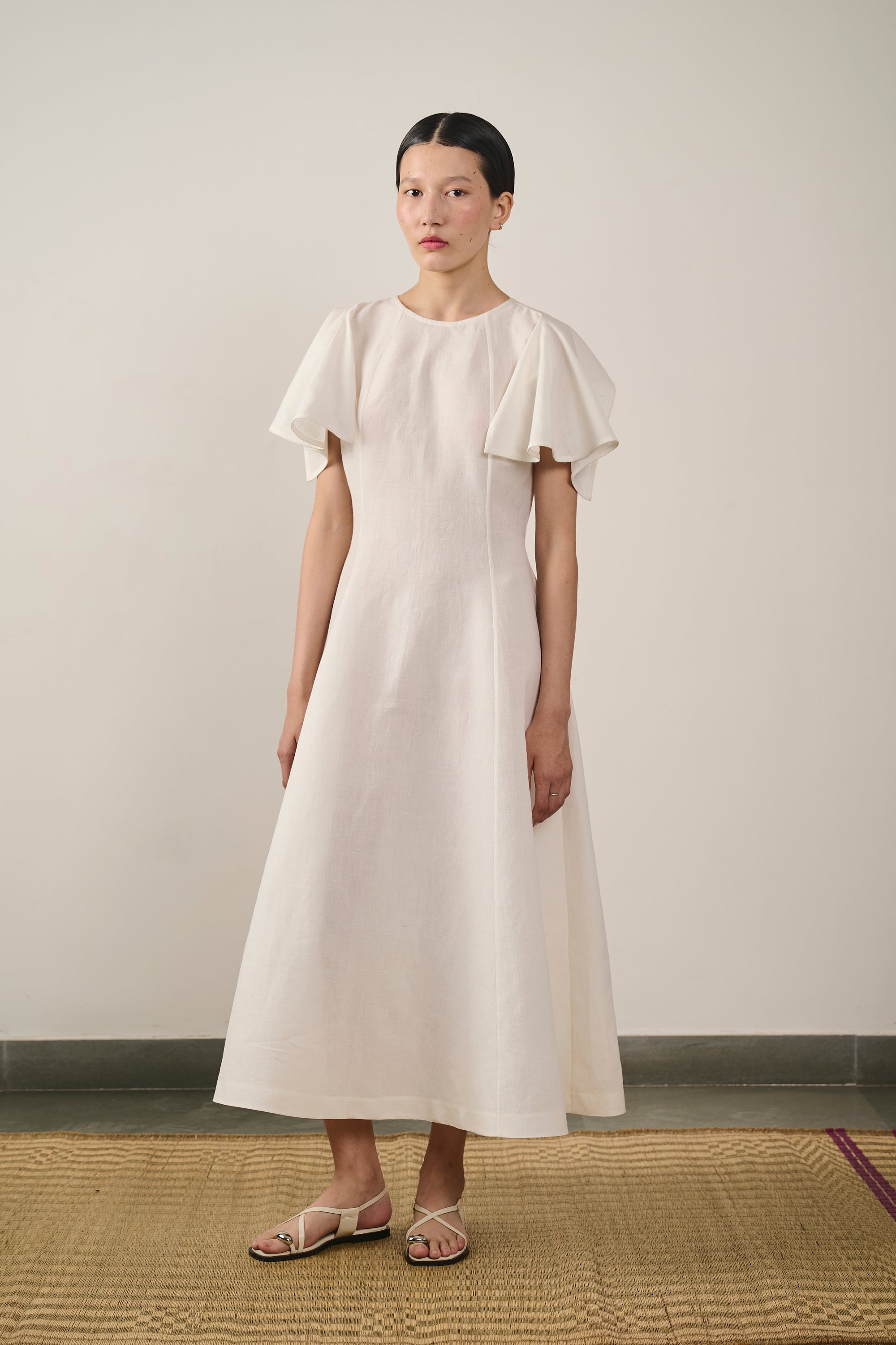 A woman wearing ecru flared dress