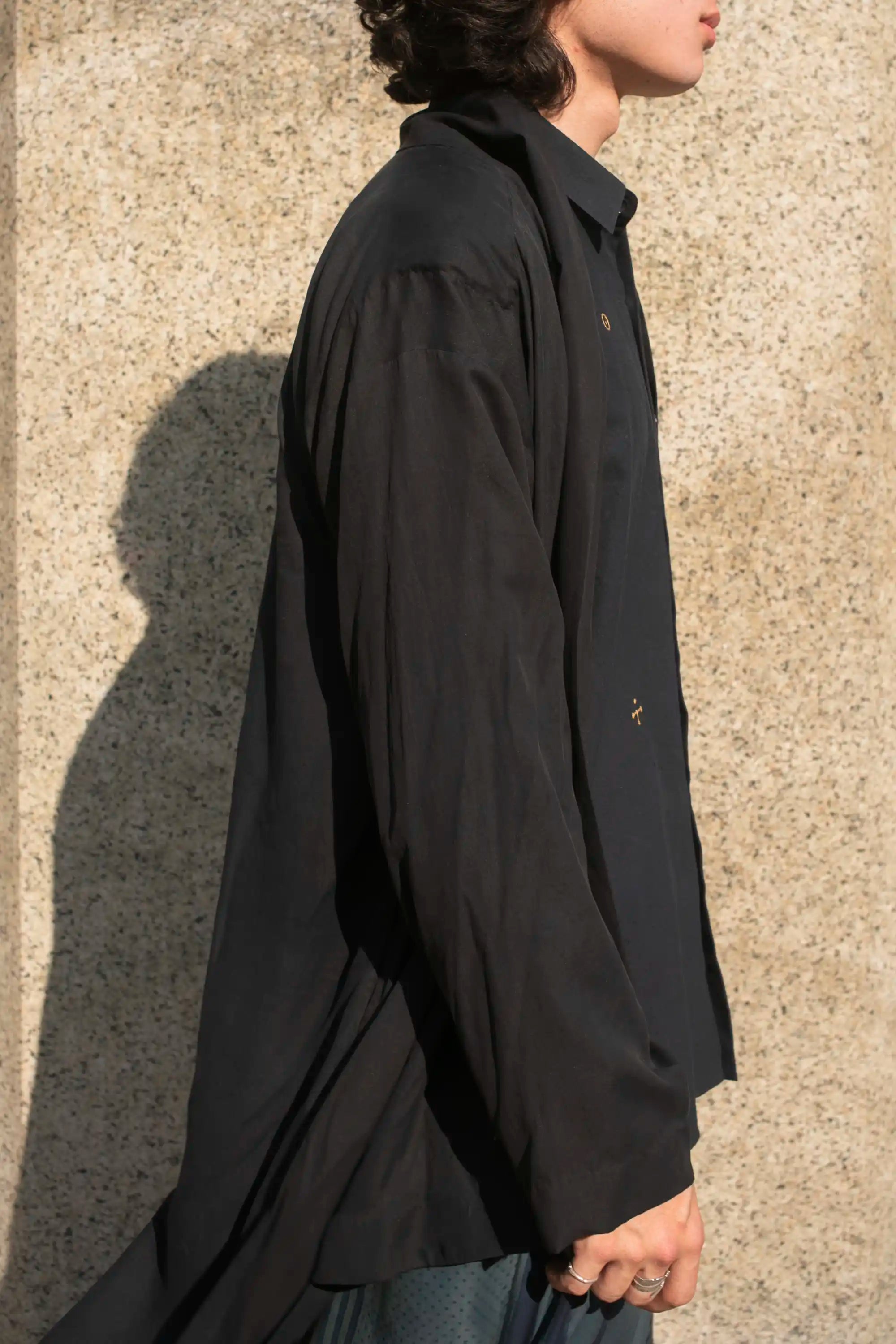 A side shot of a man wearing black jacket
