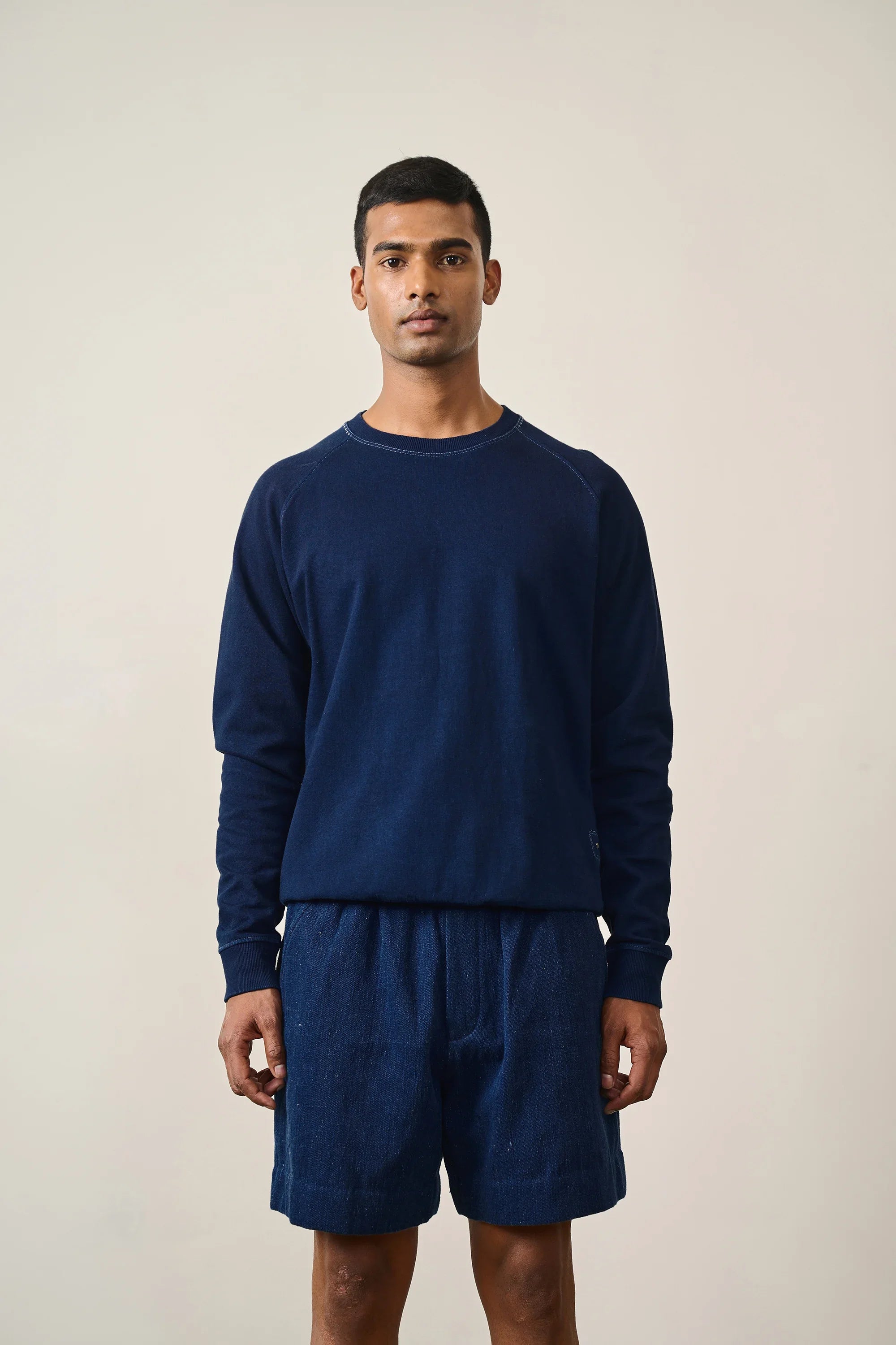 A man wearing indigo sweatshirt
