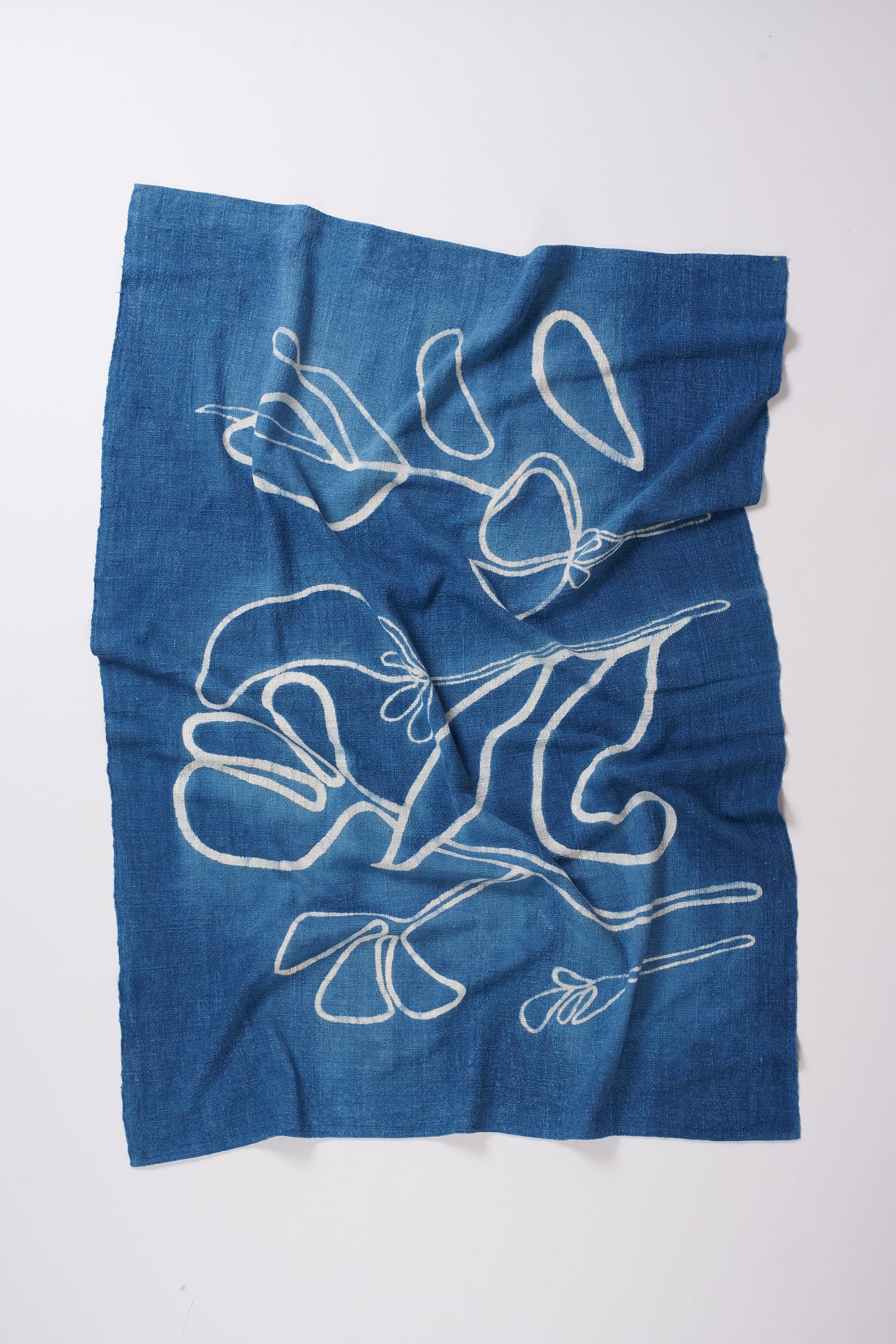 Indigo towel with white floral print on a grey background