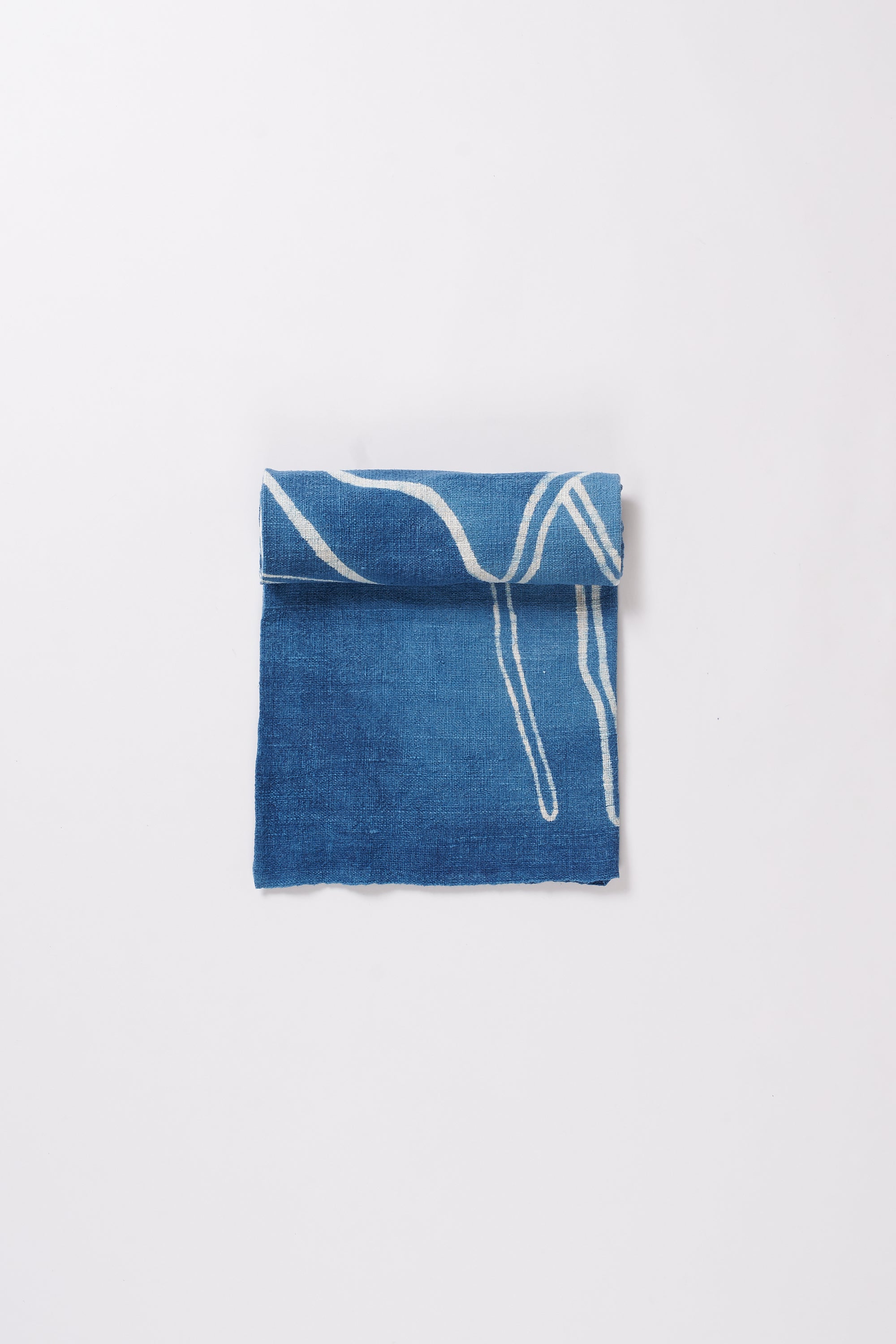 Indigo cotton towel roll on a light grey background