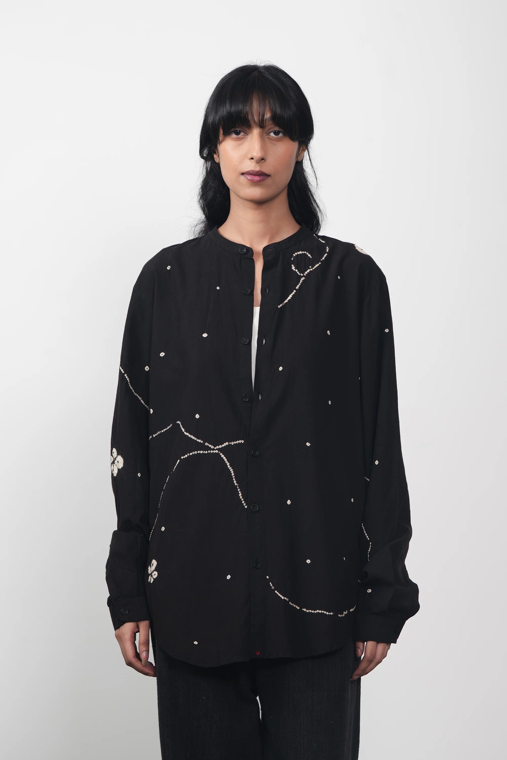A woman wearing black bandhani shirt