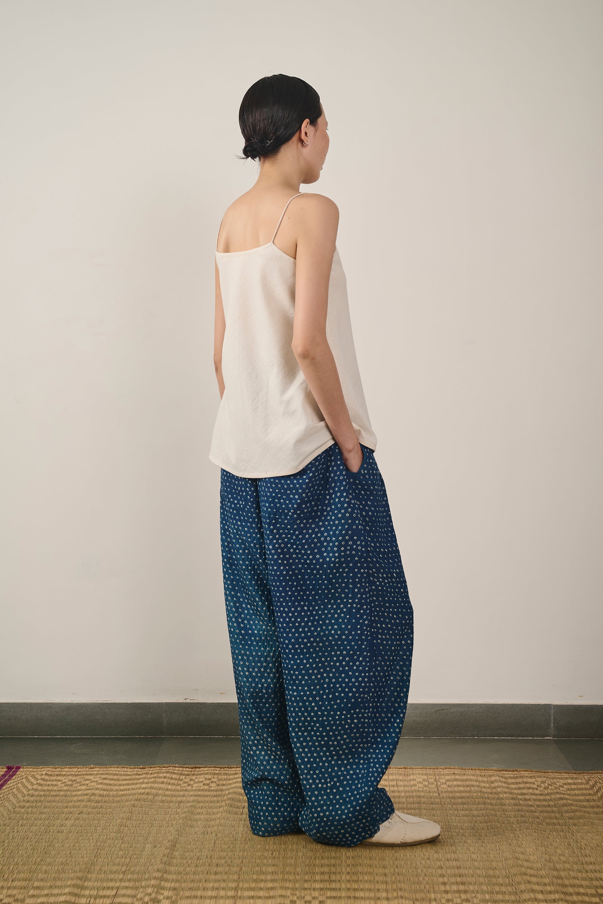 A side shot of a woman wearing medium indigo pant