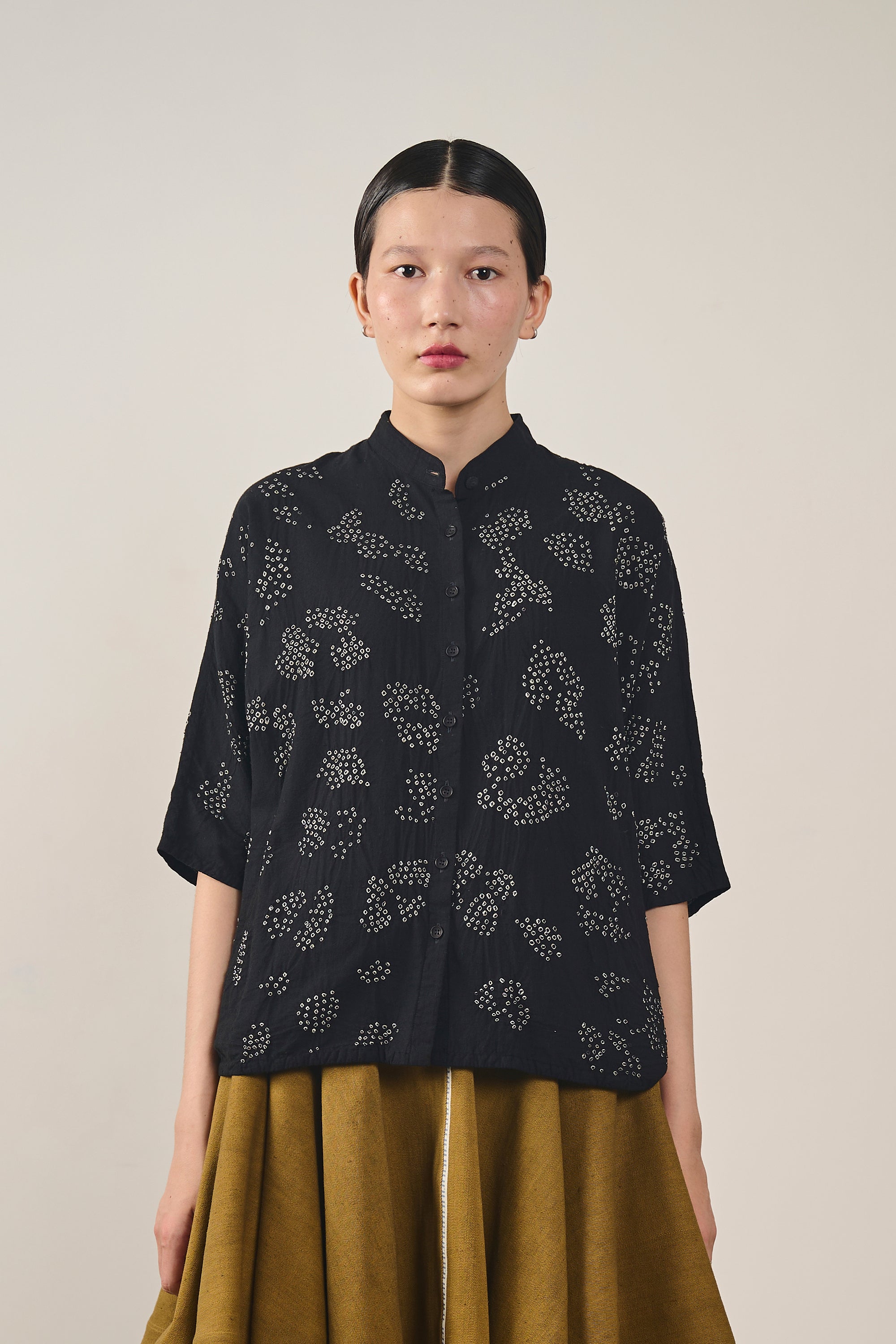 A women wearing a black bandhani shirt 