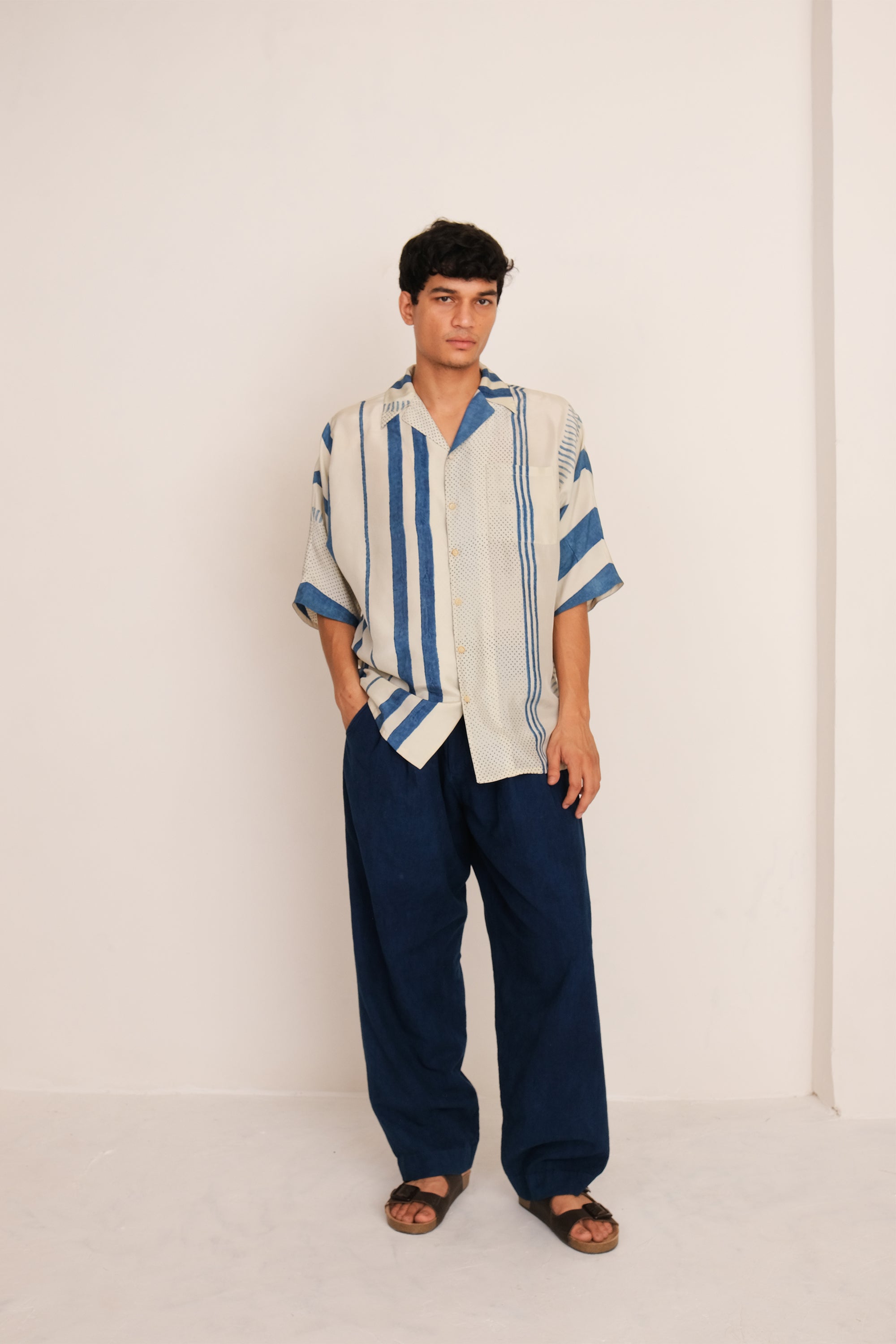 A man wearing ecru block printed shirt