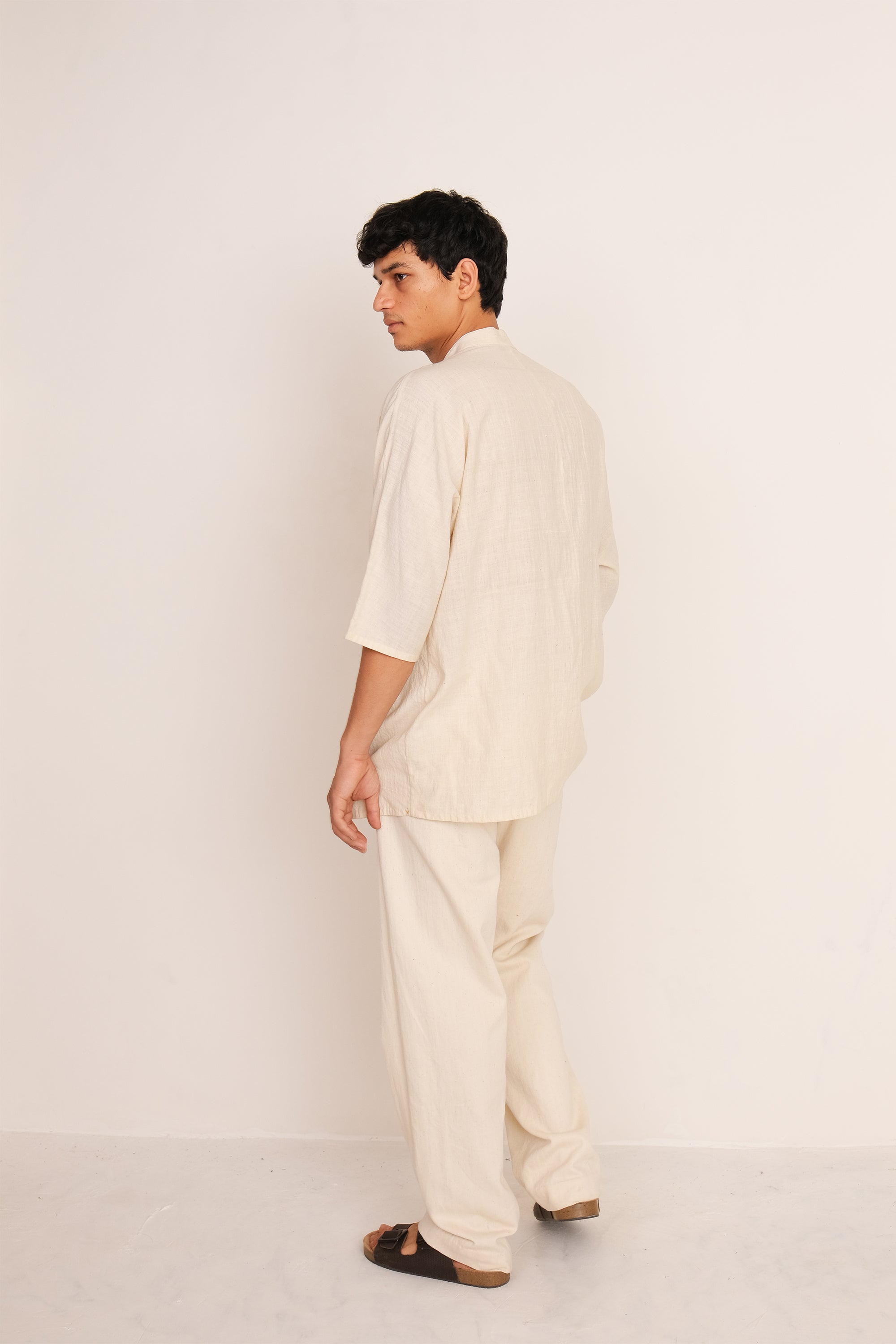 A back shot of a man wearing ecru pant