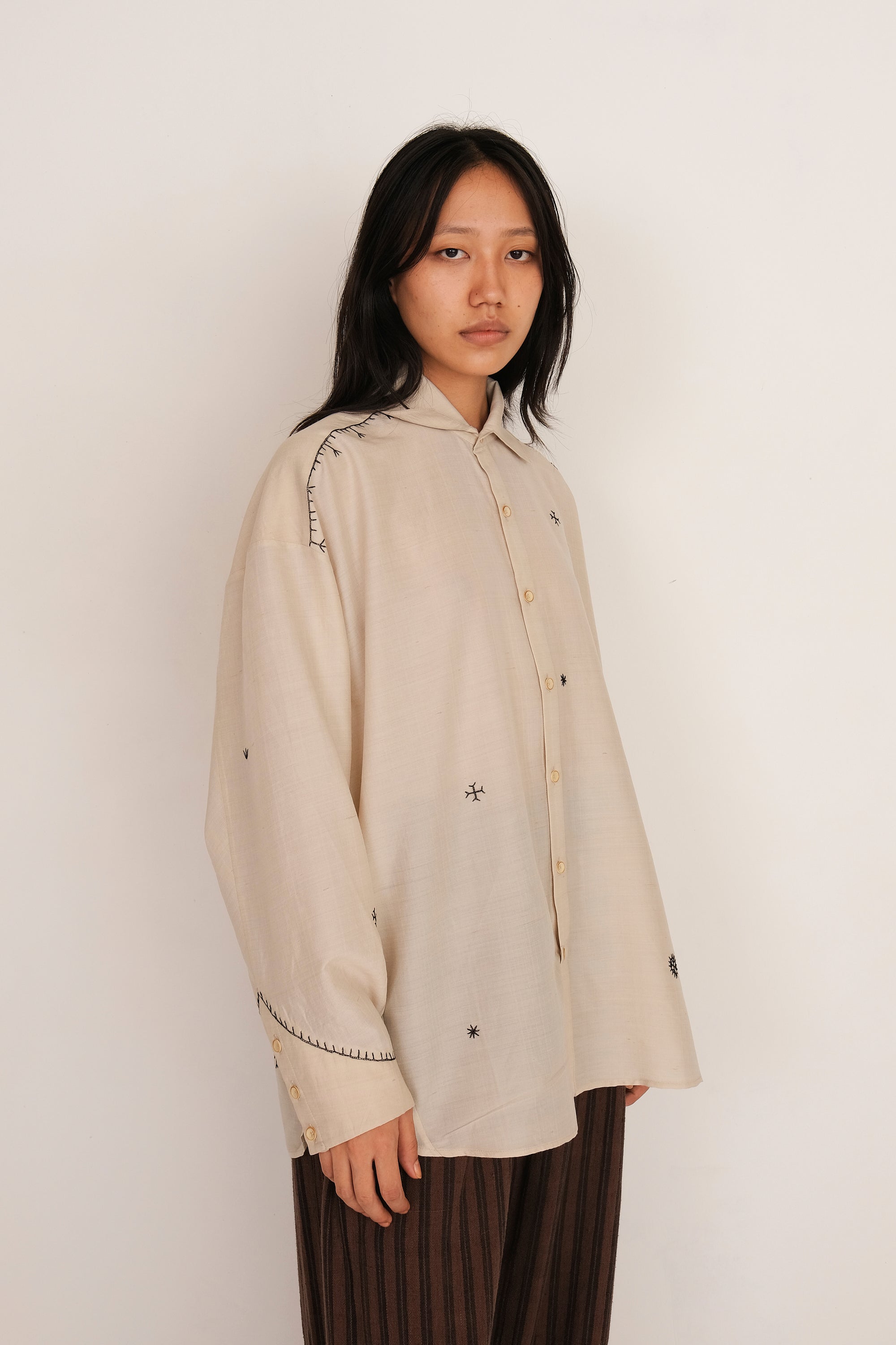 A woman wearing ecru shirt
