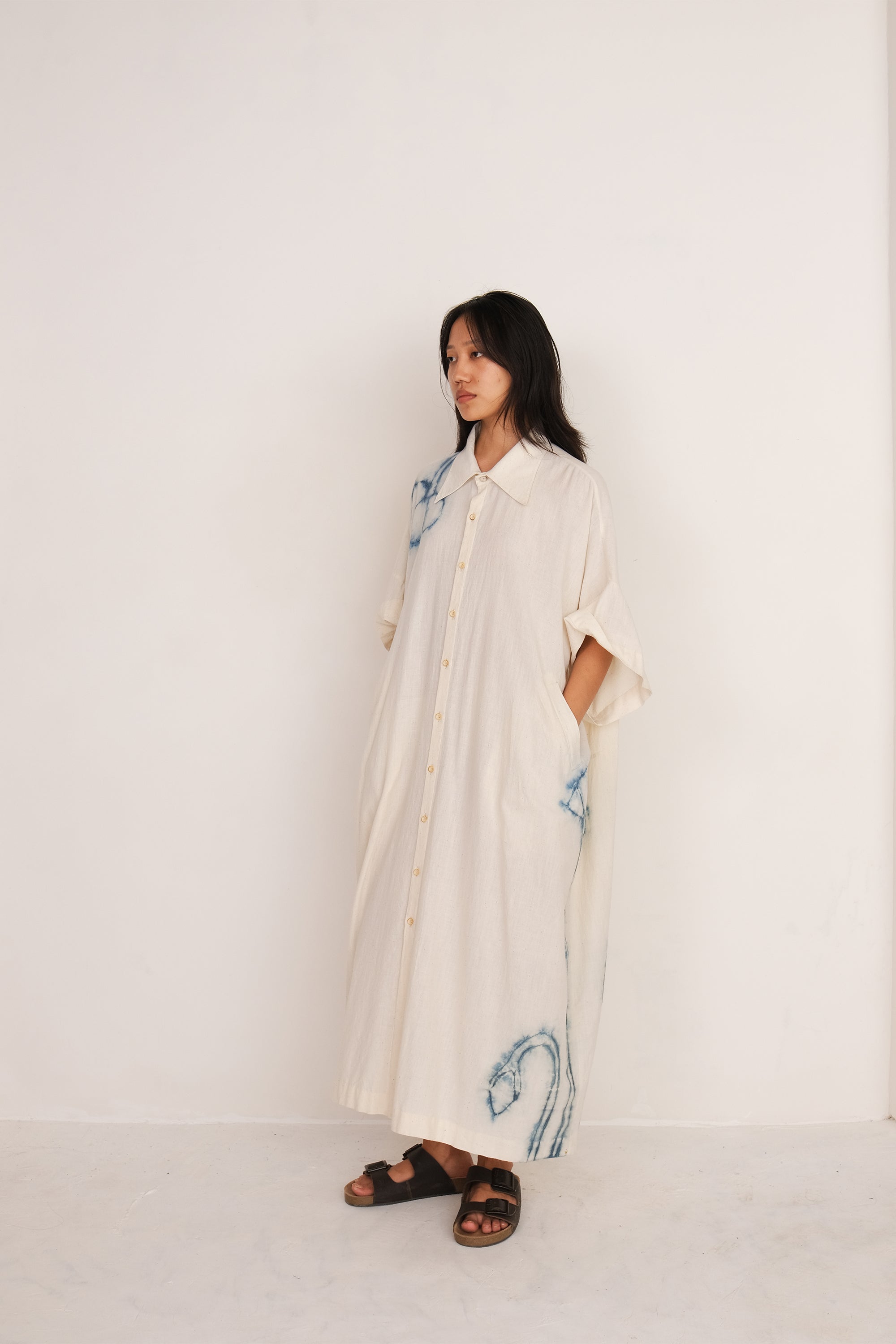 A side shot of a woman wearingecru shibori kaftan