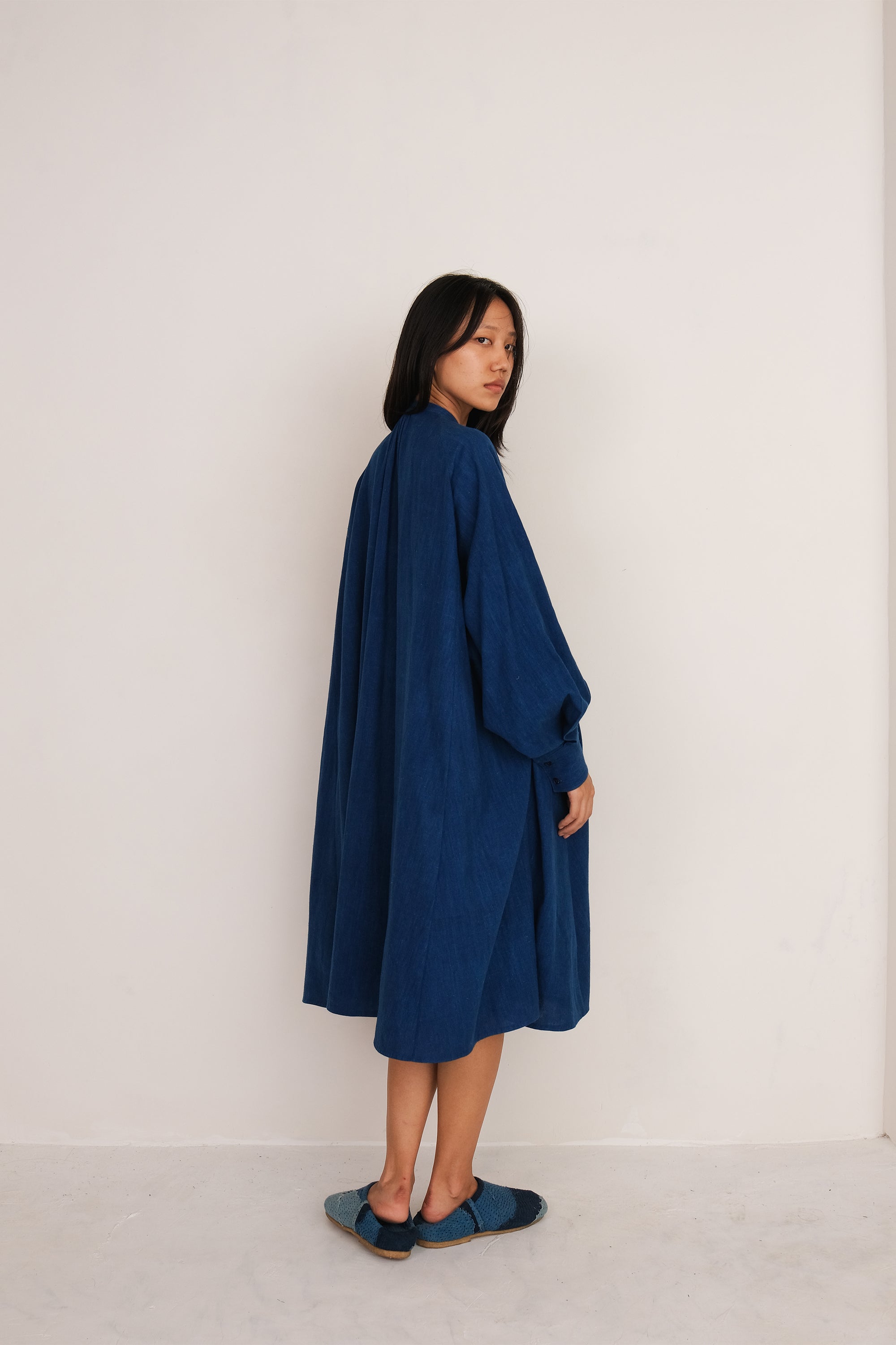 A woman wearing medium indigo cotton dress