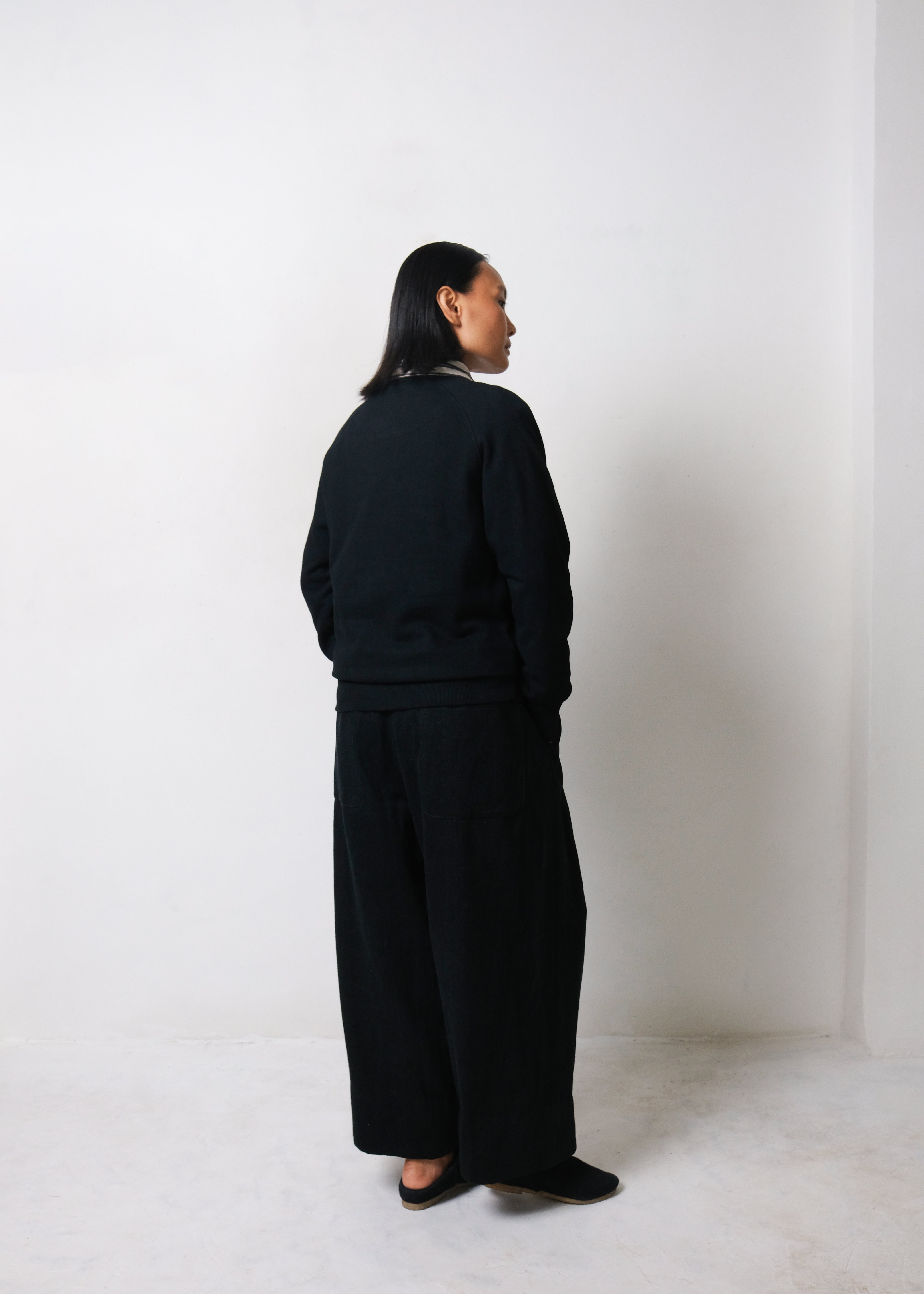 A back shot of a woman wearing black sweatshirt