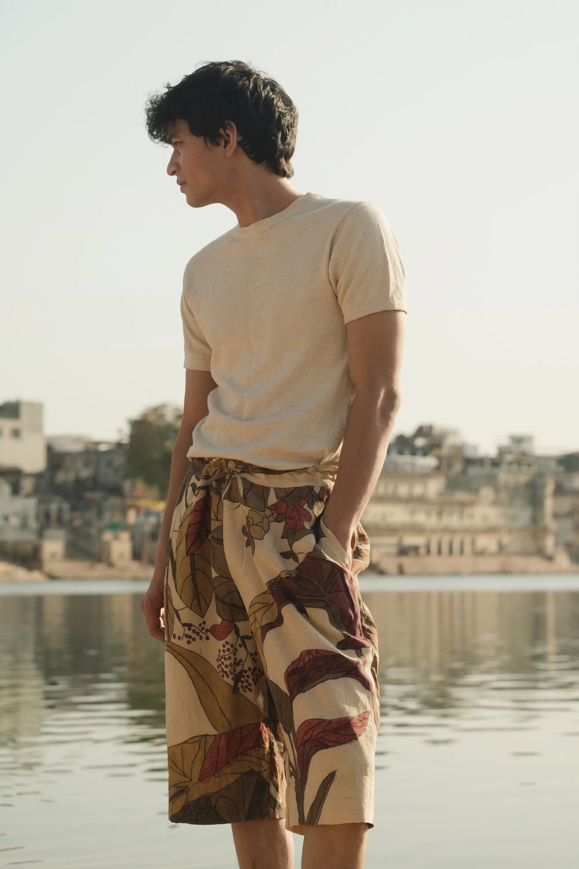A man wearing a hand painted short with ecru t-shirt