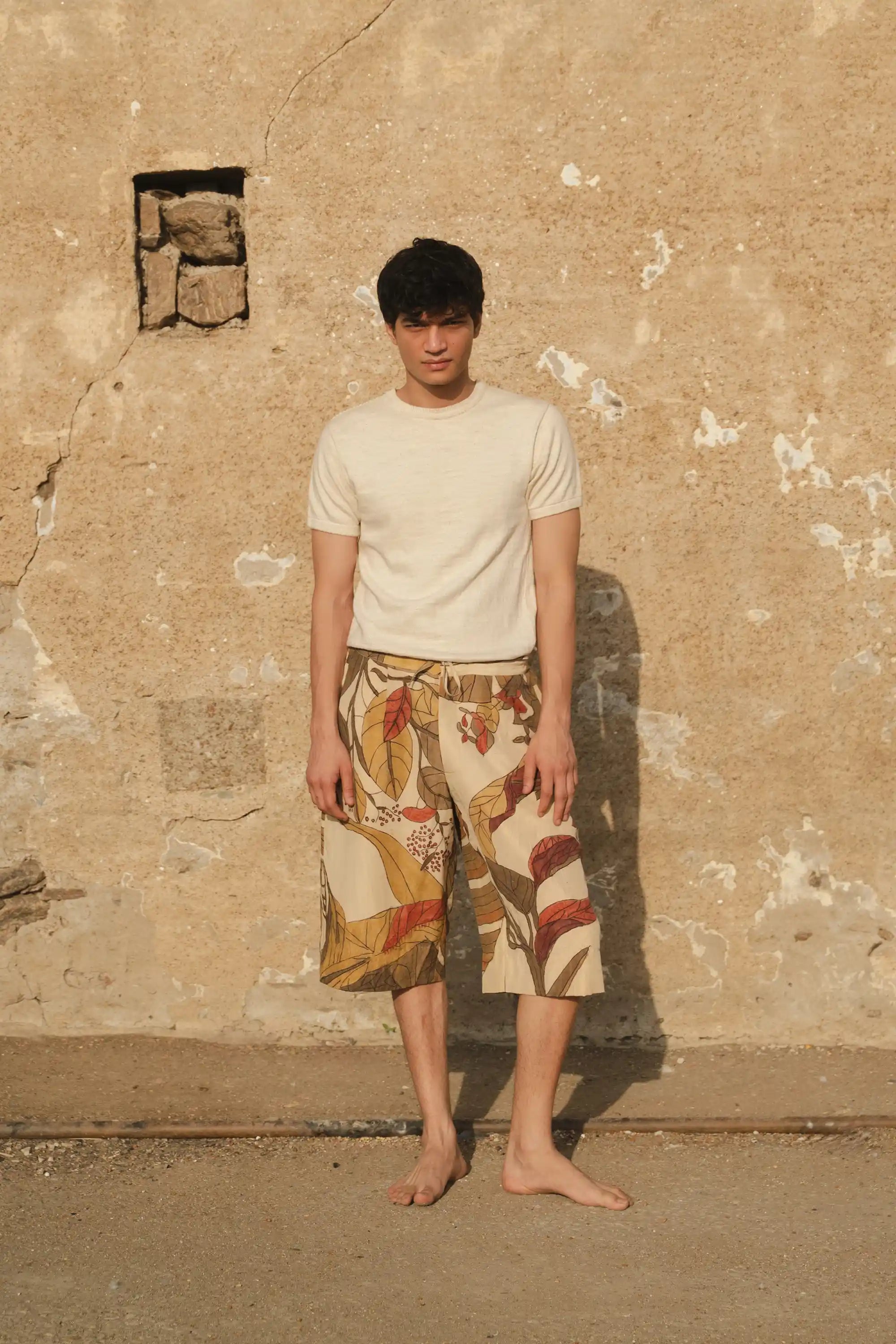 A man wearing a hand painted shorts with ecru cotton t-shirt