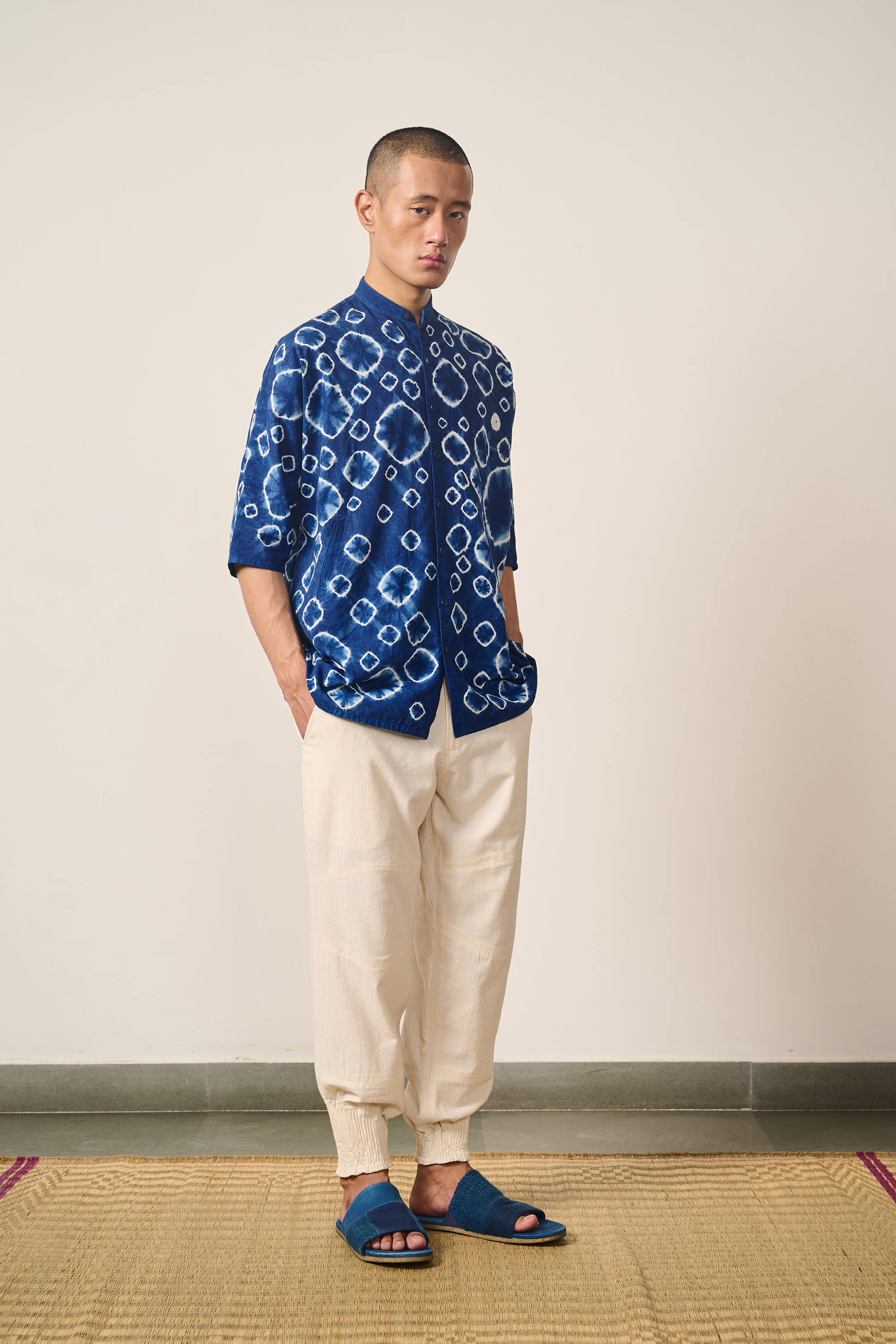 A side shot of a man wearing indigo shibori shirt