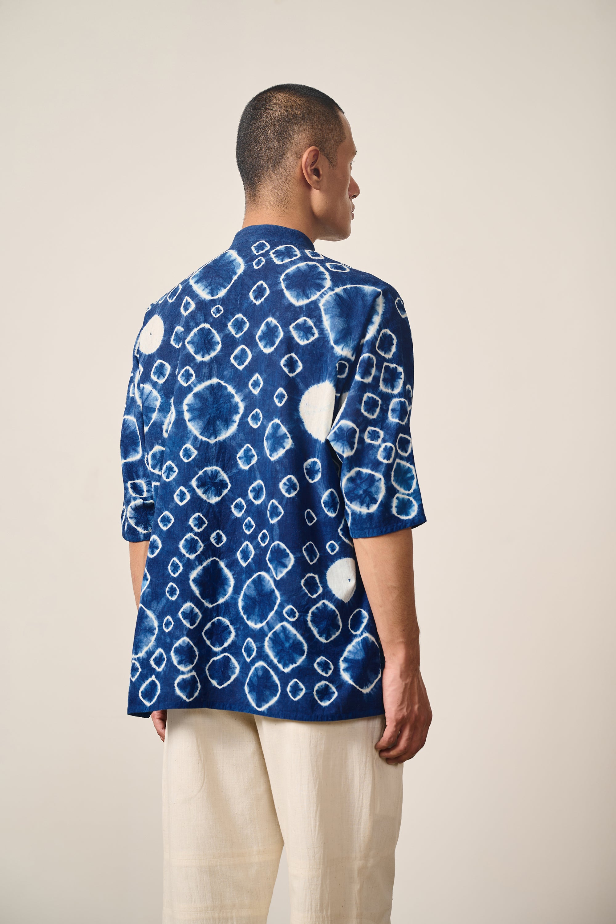 A back shot of a man wearing indigo shibori shirt