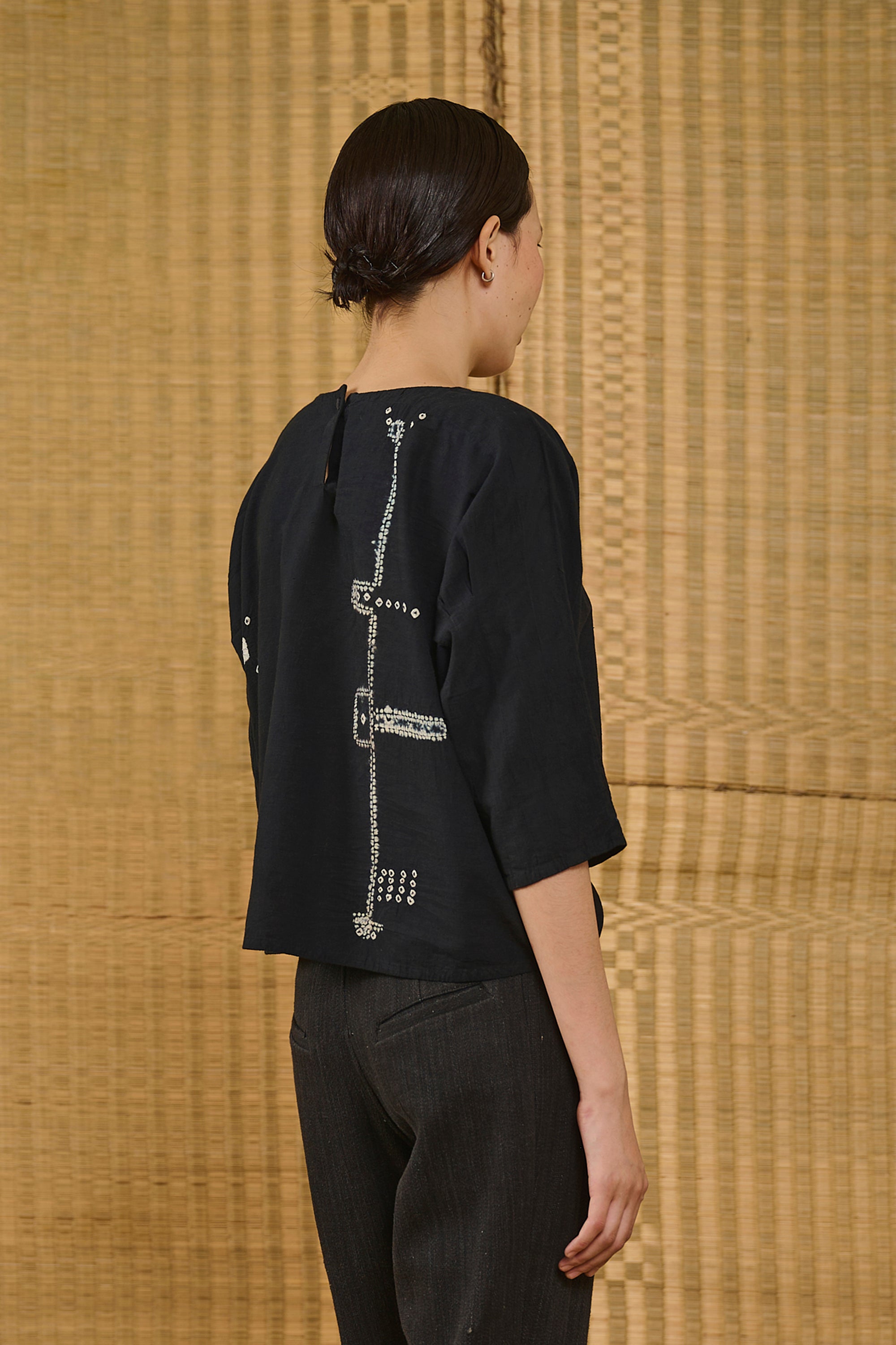 A back shot of a woman wearing black top