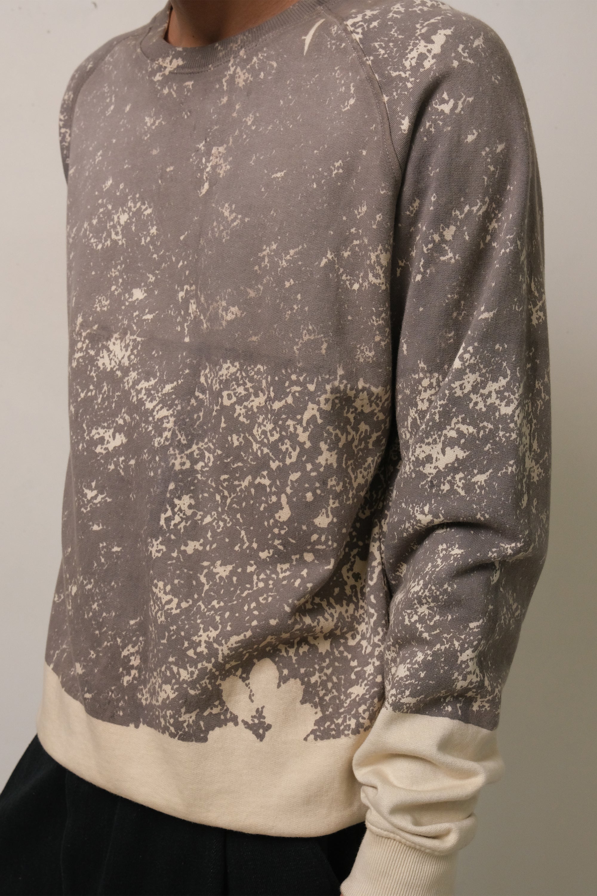 Close-up shot of a man wearing charcoal screen printed sweatshirt