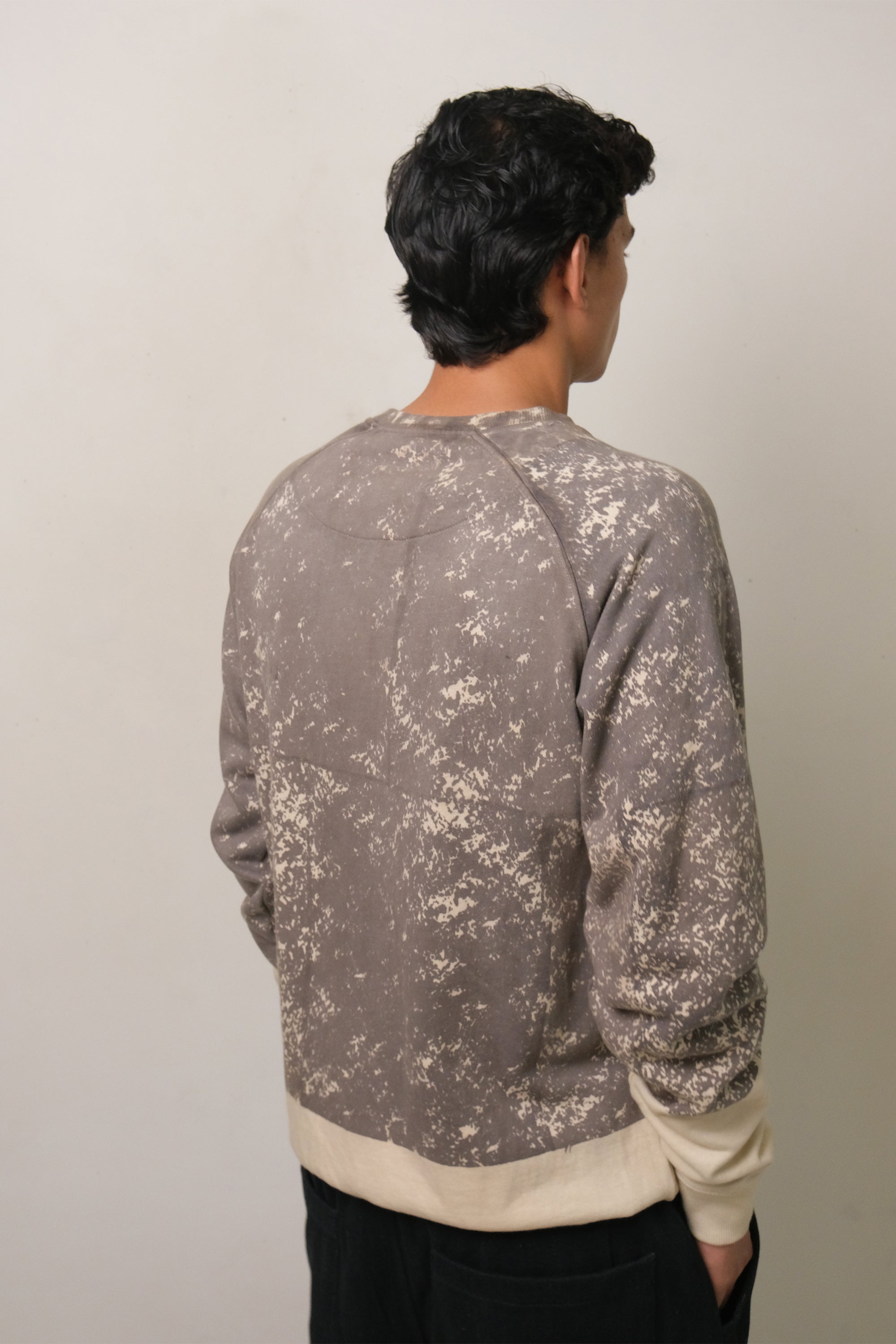 A back shot of man a wearing charcoal screen printed sweatshirt