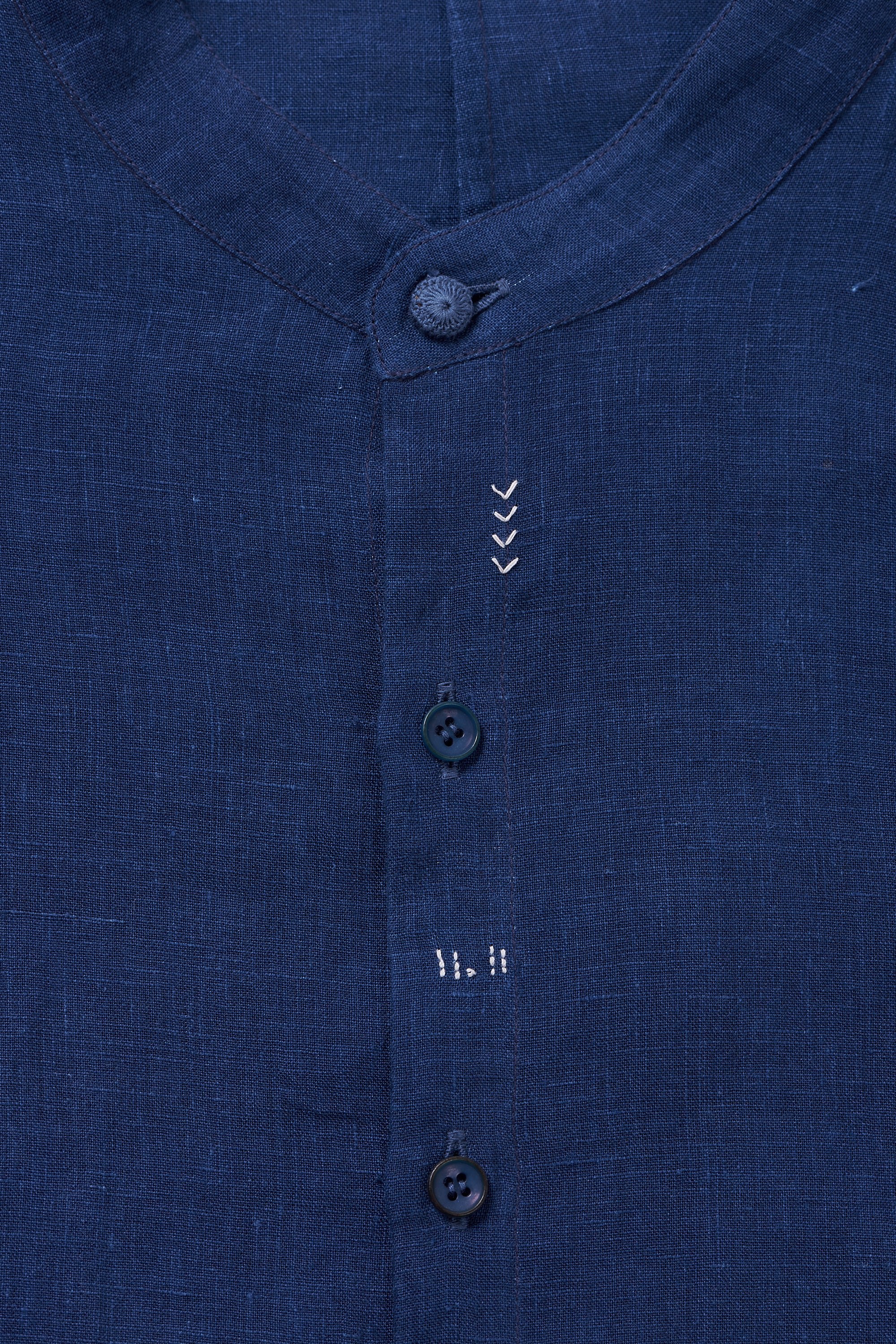 A close-up shot of medium indigo shirt with buttons