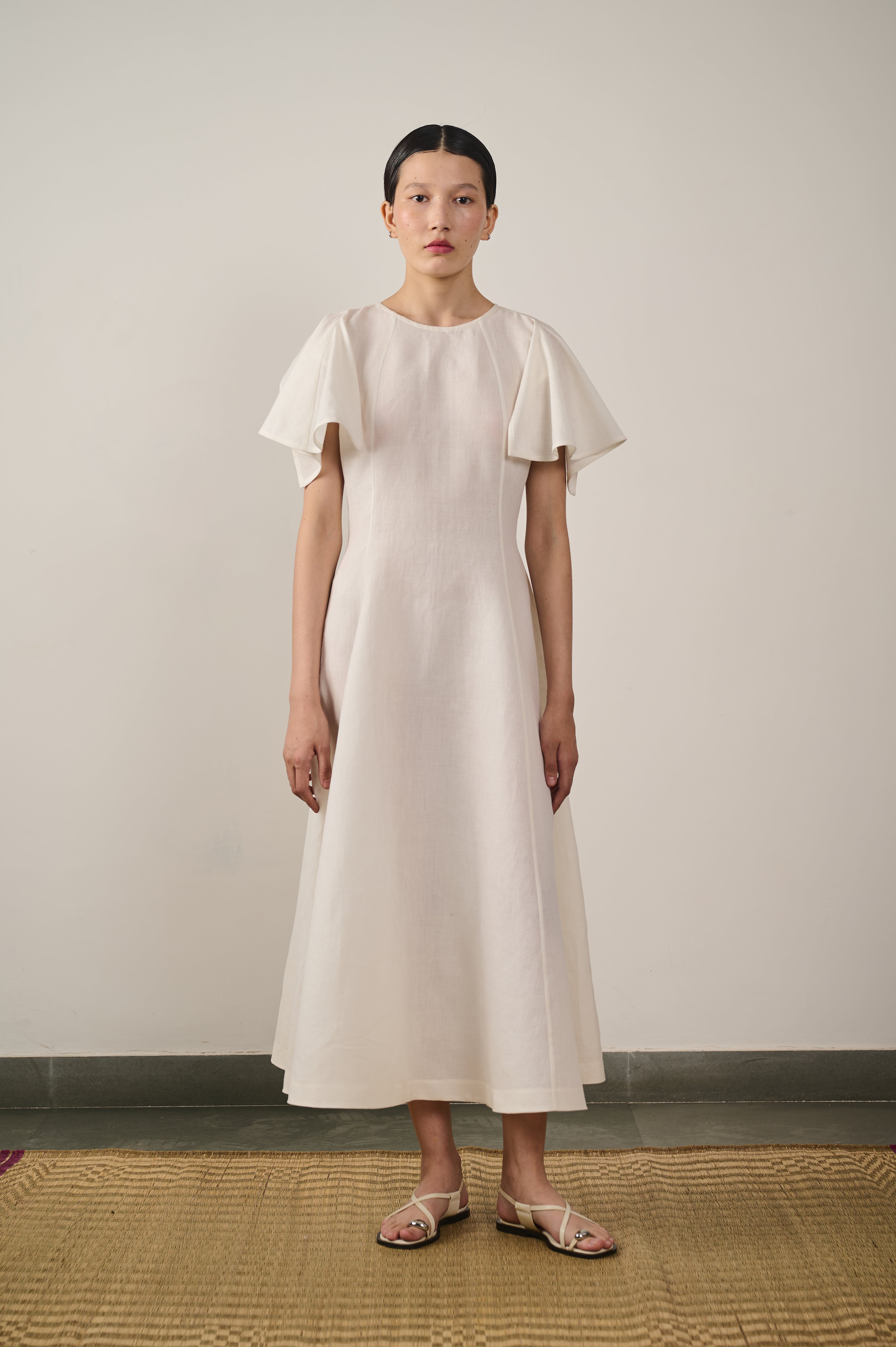 A woman wearing ecru flared dress