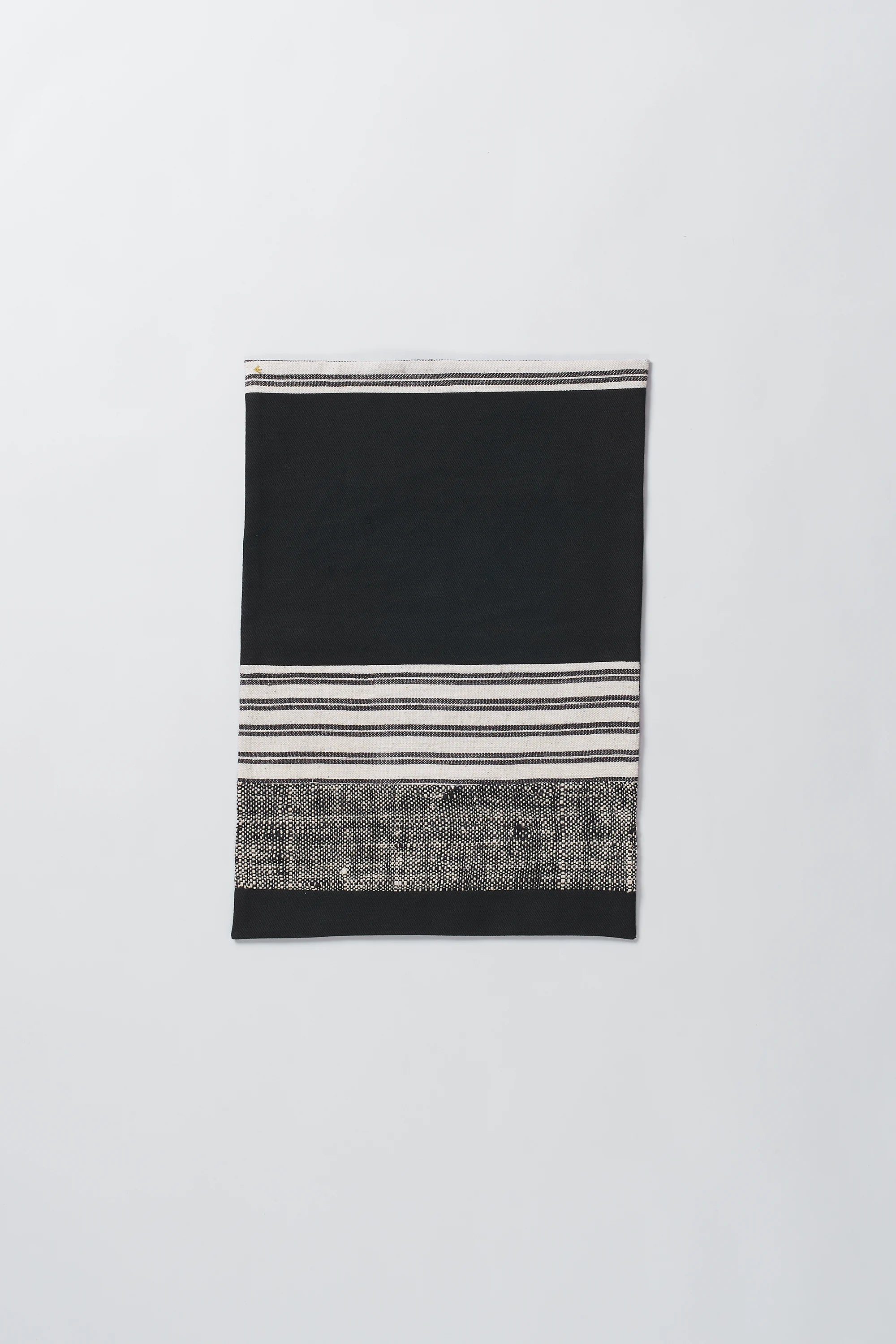 Black cotton placemat on a light grey background