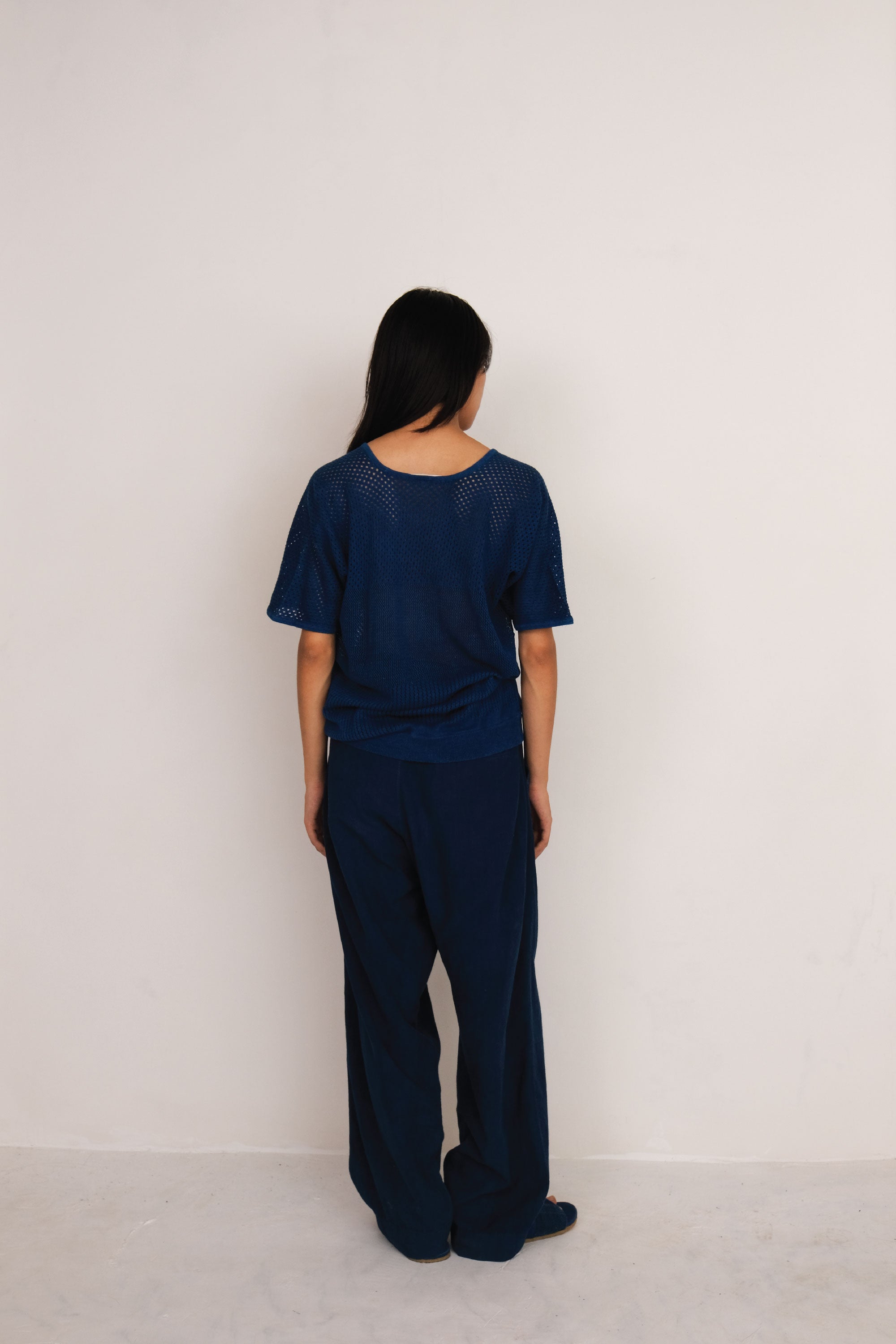 A back shot of a woman wearing medium indigo t-shirt