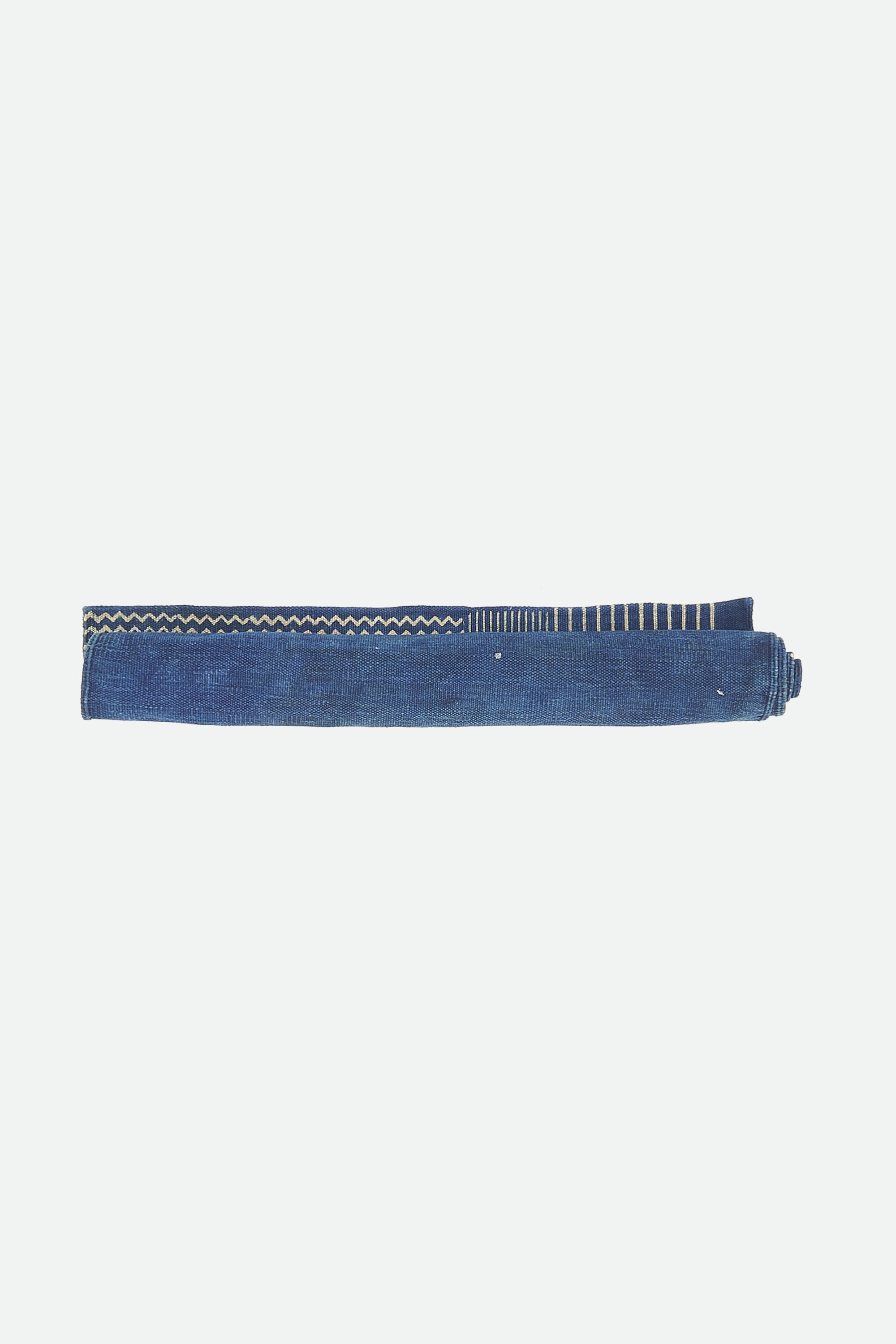 Indigo multi colour quilt roll on a white background