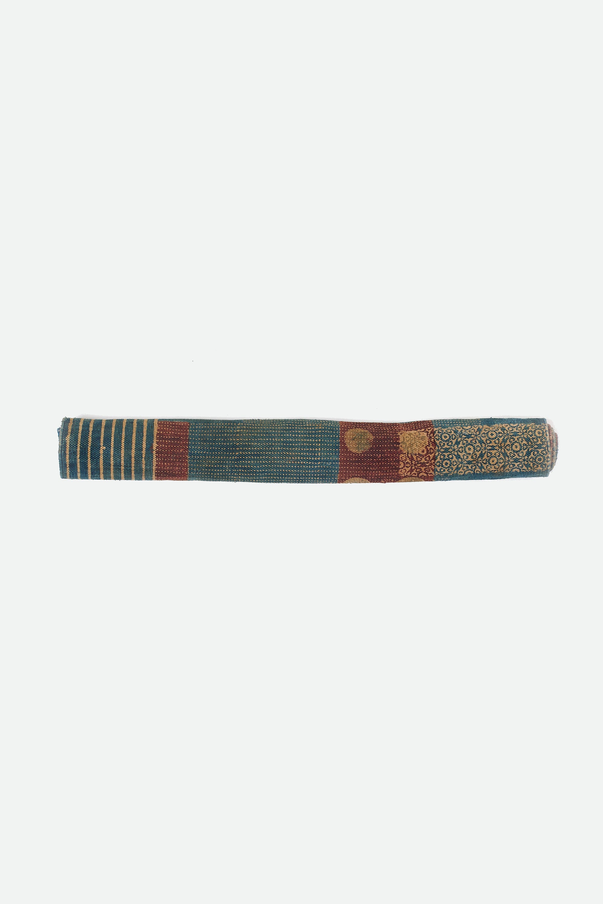 Multi colour cotton block printed quilt roll on a white background